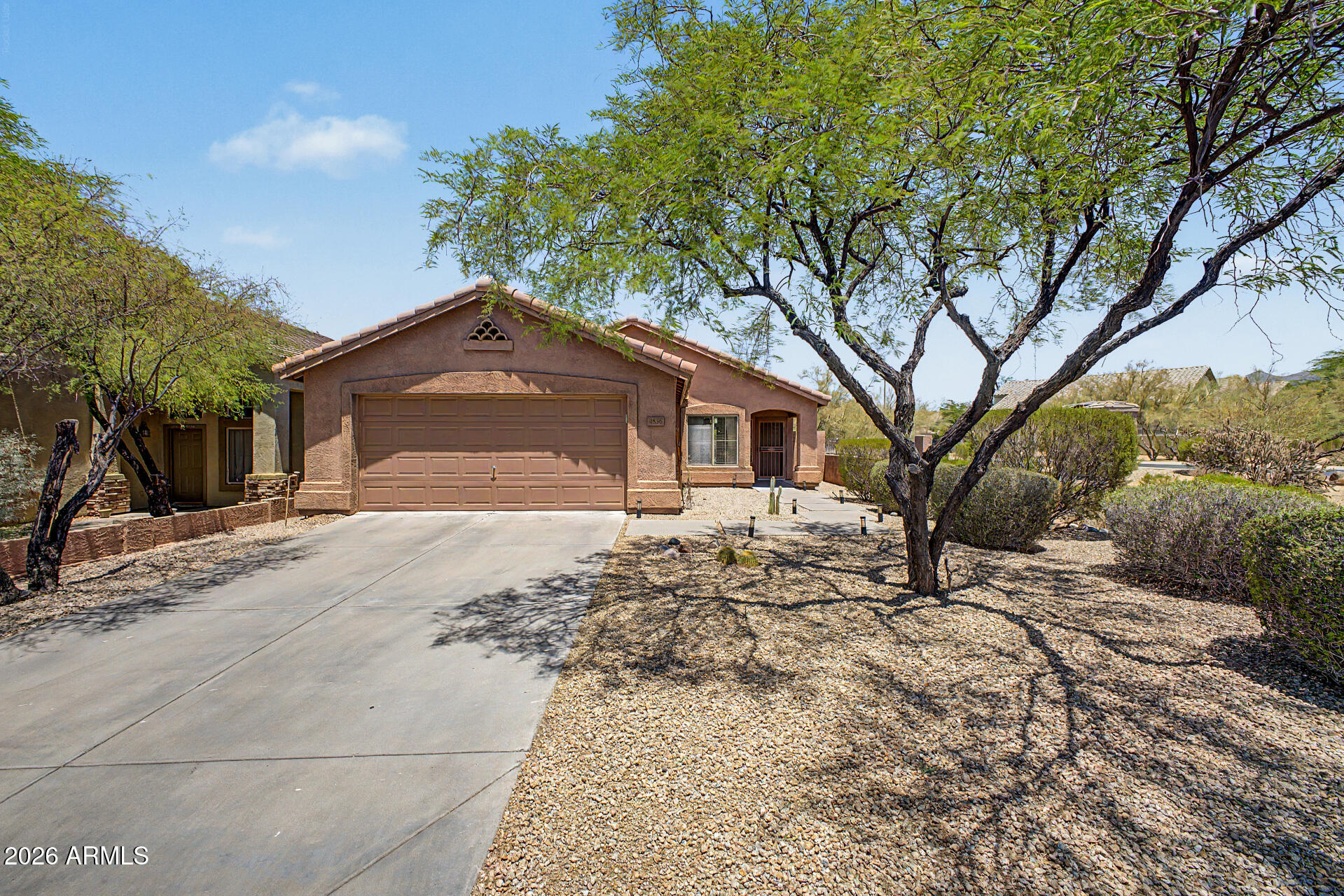 Cozy single-level home in the gated community of Dove Valley Ranch! A wonderful opportunity to own a rare premium corner lot boasting a private side and backyard - with a mountain view. Offering 3 bedrooms, 2 baths, 2-car garage, & manicured landscape. The interior showcases abundant natural light, vaulted ceilings, neutral paint, tile flooring in common areas, and carpet in bedrooms. The kitchen features built-in stainless steel appliances, granite counters throughout, wood cabinetry, a pantry, and a center island. Primary bedroom has a walk-in closet and a dual granite vanity. Washer, dryer, stay! Security door & BBQ  grill are a plus! Enjoy the tranquil backyard with a covered patio, lush lawn, view fence, & a shade tree! Welcome Home 85331