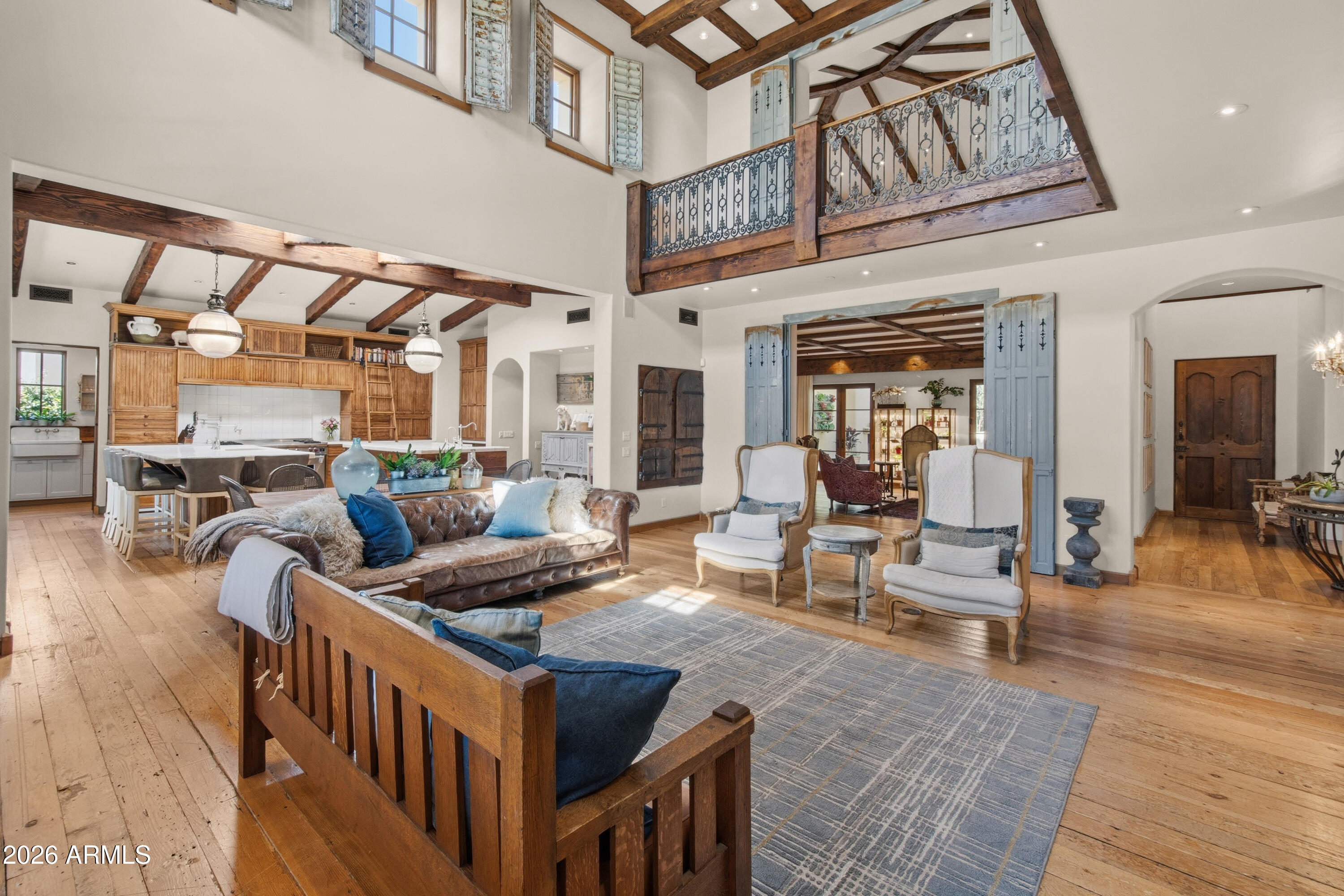 An exceptional storybook home by Candelaria Designs, reconstructed in 2008, blends new Mediterranean with modern elements & attentively curated antique finishes. 100-year-old Iowa barn wood flooring to 1800s Parisian doors, each room tells a story in a warm & authentic setting. Take to the pool/spa & 1,400 sq ft patio with expansive outdoor kitchen surrounded by enchanting half-acre gardens, twice featured on the cover of Phoenix H&G. Interior highlights include dual kitchen islands, hand-built cabinetry & wood-cased windows. All 5 bedrooms on the main level. Upstairs, a library overlooks the open great room & a game room features Juliet balconies. Additional moments include a planting room, basement speakeasy, fruit tree arboretum, courtyard entry, & 5 distinctively finished fireplaces.