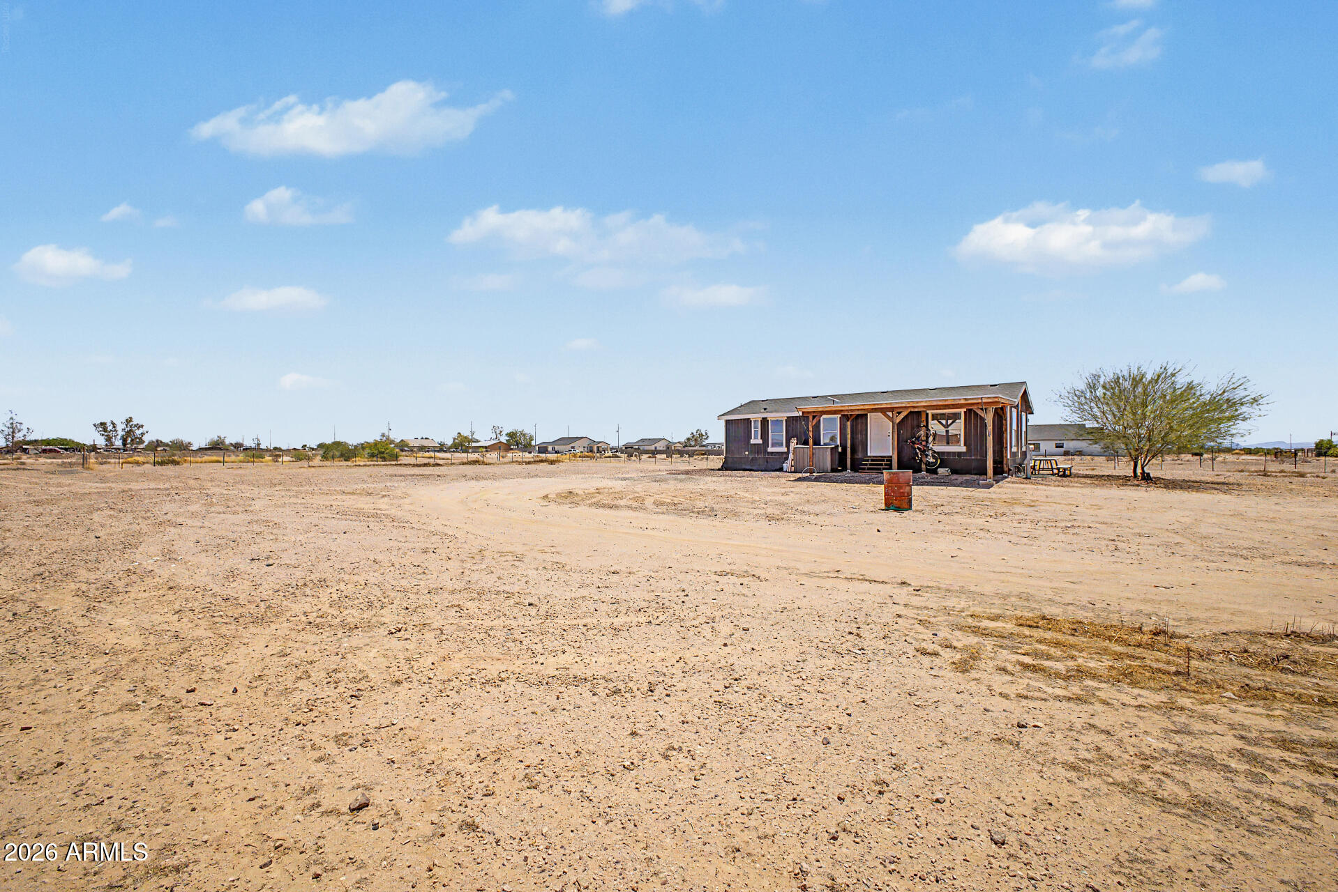 Experience the charm of country living on this incredible horse property on a HUGE 1.25-acre lot! This property features a charming 2-bedroom manufactured home and endless possibilities. The versatile 2-car carport can be your covered outdoor sitting area. Inside, you'll find a desirable open layout with bountiful natural light, vaulted ceilings, a neutral palette, and wood-look flooring t/out. The kitchen boasts an SS elec range w/hood, butcher block counters, subway tile backsplash, recessed lighting, and white shaker cabinetry. The main bedroom has a walk-in closet and a private bathroom. EXPANSIVE YARDS! Bring your horses, RVs, trucks, and toys; this gem offers plenty of room to roam and grow. Enjoy wide-open skies, mountain views, and the tranquility of rural living! What a RARE find!