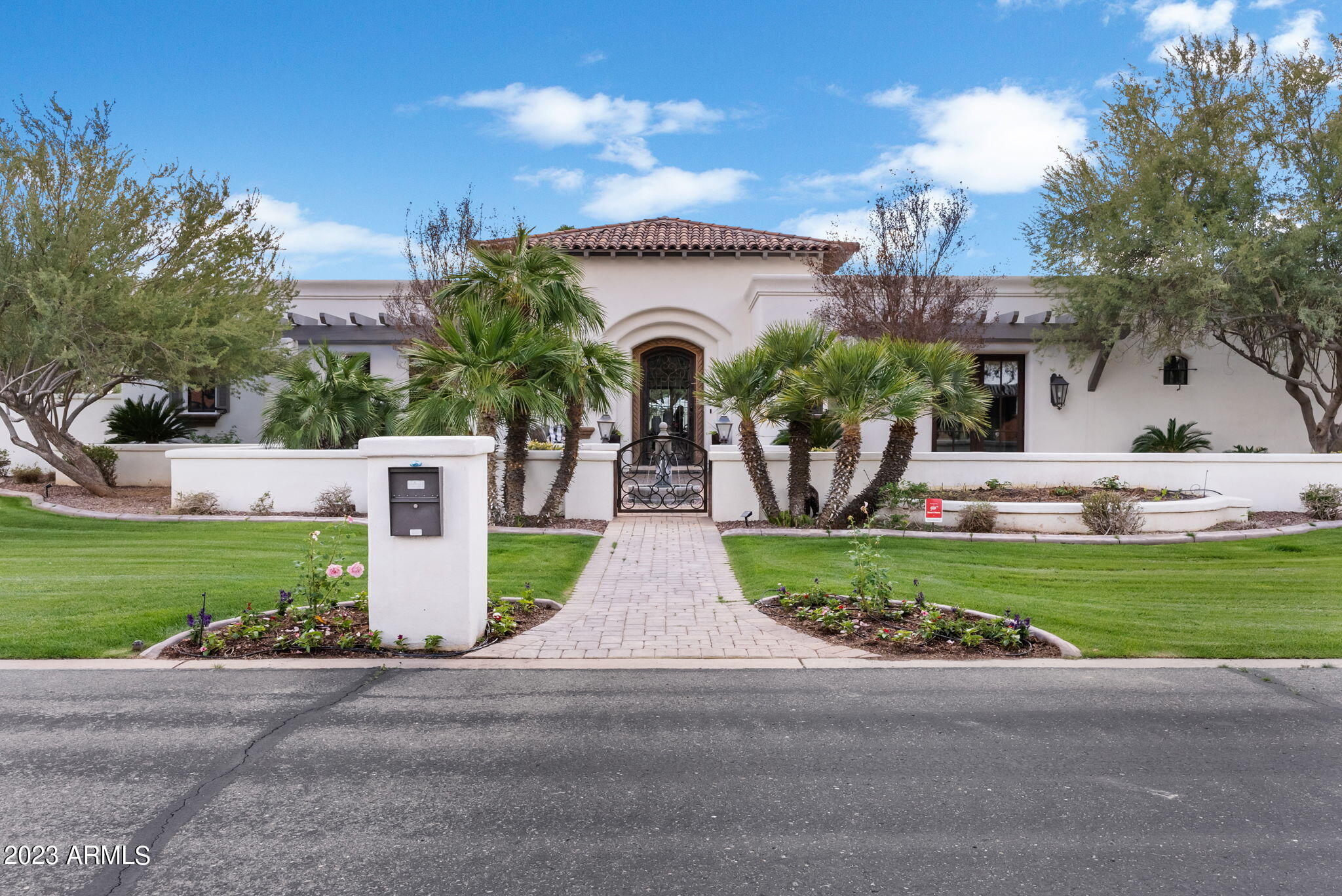 Gorgeous Spanish Revival home in Camelback Country Club Estates exudes distinctive character and elegant style renovated by THELIFESTYLEDCO. Spacious 6,720 SF main home is filled with natural light, organic finishes and curated luxury features. Upon entering the chic circular foyer, you are drawn to the living room boasting an auto touch wall of cascading glass doors that open to an outdoor oasis perfect for Arizona's indoor/outdoor living. Dream kitchen designed for entertaining with generous island, 6 burner Wolf gas stove with 2 ovens, Sub Zero fridge/freezer, multiple dishwashers and walk-in pantry. Opens to large family room with wood beams, fireplace and large windows that provide a feeling of comfort and serenity. Butler's pantry is well equipped with ice maker, wine storage and refrigerator drawers. Stunning dining room is complete with a temperature controlled 850 bottle wine wall. Retreat to the romantic owner's suite with fireplace and private patio. Spa inspired bathroom features a huge island with generous storage, his and hers vanities and closets and a luxurious steam shower and soaking tub. Double doors lead to spacious children's/guest wing with 3 bedrooms, 2 bathrooms, second laundry room and a flex space. Third bedroom has a large walk-in closet that is currently used as an exercise room.  Additional ensuite bedroom/office/playroom with custom cabinetry features French doors leading to the front courtyard. Guests will enjoy the 417 SF attached casita with kitchenette. Perfectly situated on this north/south facing lot, the outdoor entertainment area includes 3 patios, gorgeous pool & spa, double sided fireplace, built in bar with 2 new kegerators and gas grill, pool bath, and plenty of lush mature landscape with mountain views.