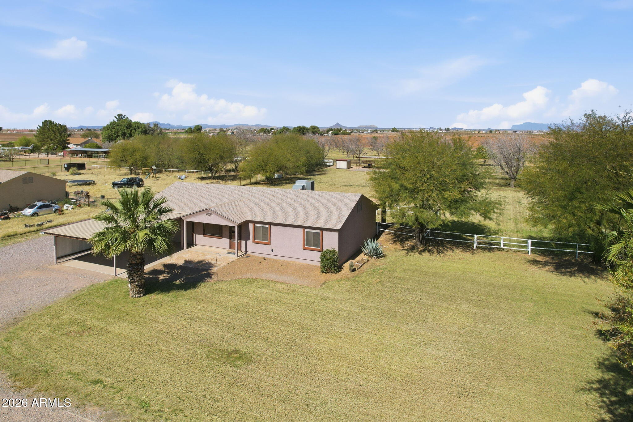 This 3-bedroom, 2-bathroom home sits on 1.25 irrigated acres, offering plenty of space for horses, hobbies, or simply spreading out. The property has been well maintained and is ready for its next owner.Inside, you'll find 1,500 square feet of living space with granite countertops throughout. The home is in solid condition, so you can move in and settle right in without a lengthy to-do list. The outdoor space is a notable feature of this property. Mature trees provide shade and character throughout the acreage, making the Arizona climate more manageable. The entire property is fully fenced, providing security for children, pets, and livestock alike. For equestrian use, there are three covered horse stalls measuring 12 by 18 feet each that are fully covered, along with a wash rack. Parking and storage are well accounted for with a 2-car garage and an additional carport shade structure. There is room for vehicles, equipment, and recreational items. This property combines a well-kept home with functional acreage suited for agricultural or equestrian use. The irrigated land, fencing, and horse facilities add practical value for buyers looking for rural property with infrastructure already in place. If you've been looking for a property that offers both comfortable living and usable acreage, reach out to schedule a private showing and see it for yourself.