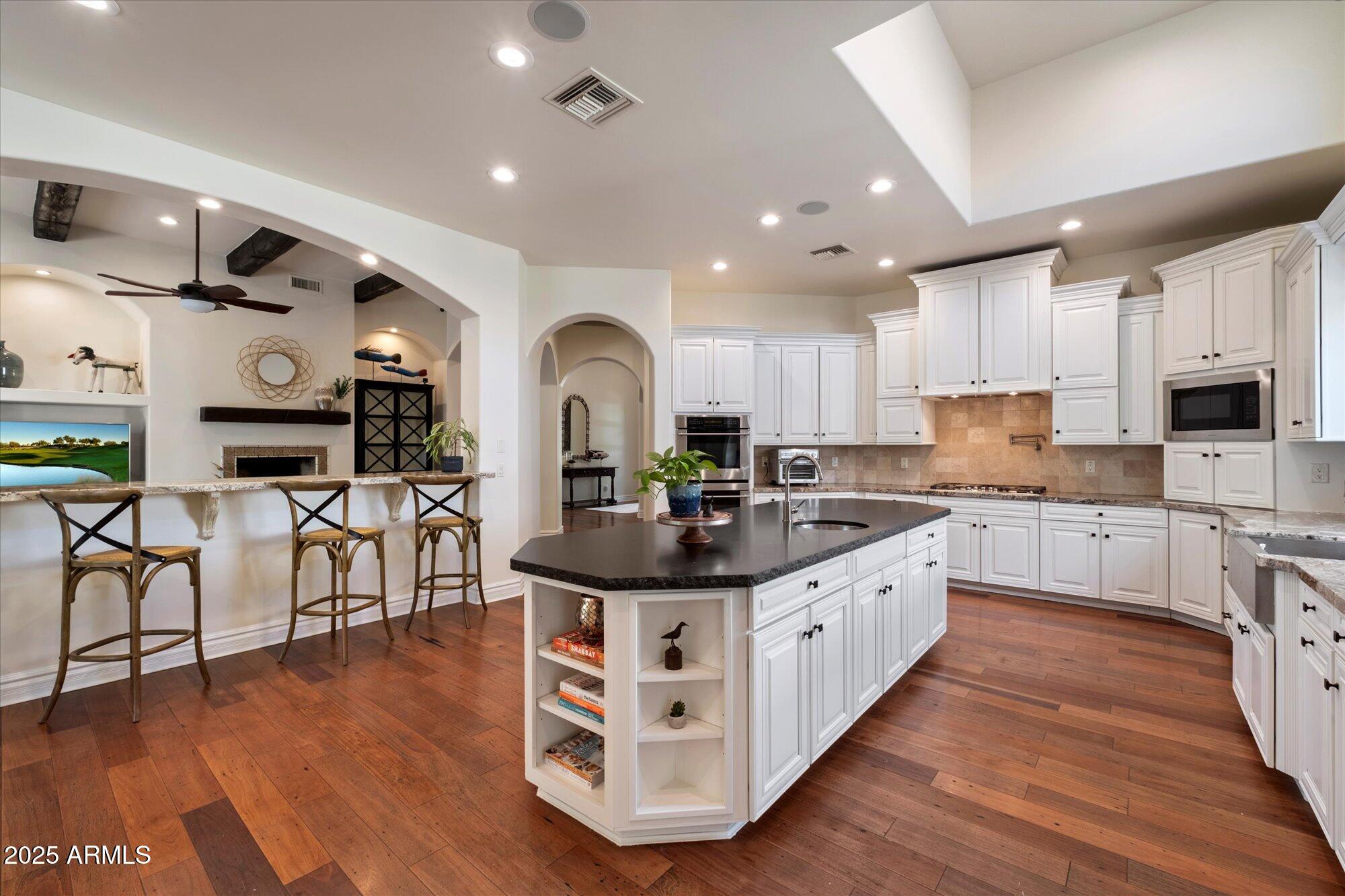 Welcome to a true Santa Barbara-style estate in the heart of the coveted 85254 ''Magic Zip Code'', with NO HOA, gorgeous arched doorways, and stunning wood-beamed ceilings throughout. This beautifully designed 6-bedroom, 6,945 sq ft residence sits on a corner lot, offering refined luxury and unbeatable entertaining potential. Inside, soaring 10'+ ceilings set the tone for elegance. The newly expanded primary suite (2025) features dual wings: ''hers'' includes a custom walk-in closet with washer/dryer, freestanding tub, 2 separate vanites and sinks and private bidet room; ''his'' wing boasts a massive steam shower, bidet, wet bar, walk-in closet, and private office/lounge with direct yard access. A custom game room/bar includes travertine tile, wine fridge, sink, microwave and ice makerplus 2 guest rooms and a full bath added in 2020 Or it can be easily converted into multi-generational living, or a guest casita with backyard access. The chef's kitchen is fully equipped with a Sub-Zero fridge, Monogram double ovens, gas stove with pot filler, refinished cabinets, new hardware, and quartz in baths/laundry (2025). The open layout flows into a cozy breakfast nook and elegant dining room with exposed beams.
Enjoy your resort-style backyard with a diving pool, fire pit, Alfa pizza oven, outdoor kitchen, above-ground spa, lush landscaping, synthetic lawn, and multiple covered patios and a ½ basketball court. With a movie theater, 1,000-gal aquarium, 3-car epoxy garage, and circular drivewaythis home is a rare blend of comfort, privacy, and sophistication. Easy access to freeways, shopping, restaurants and outstanding schools!