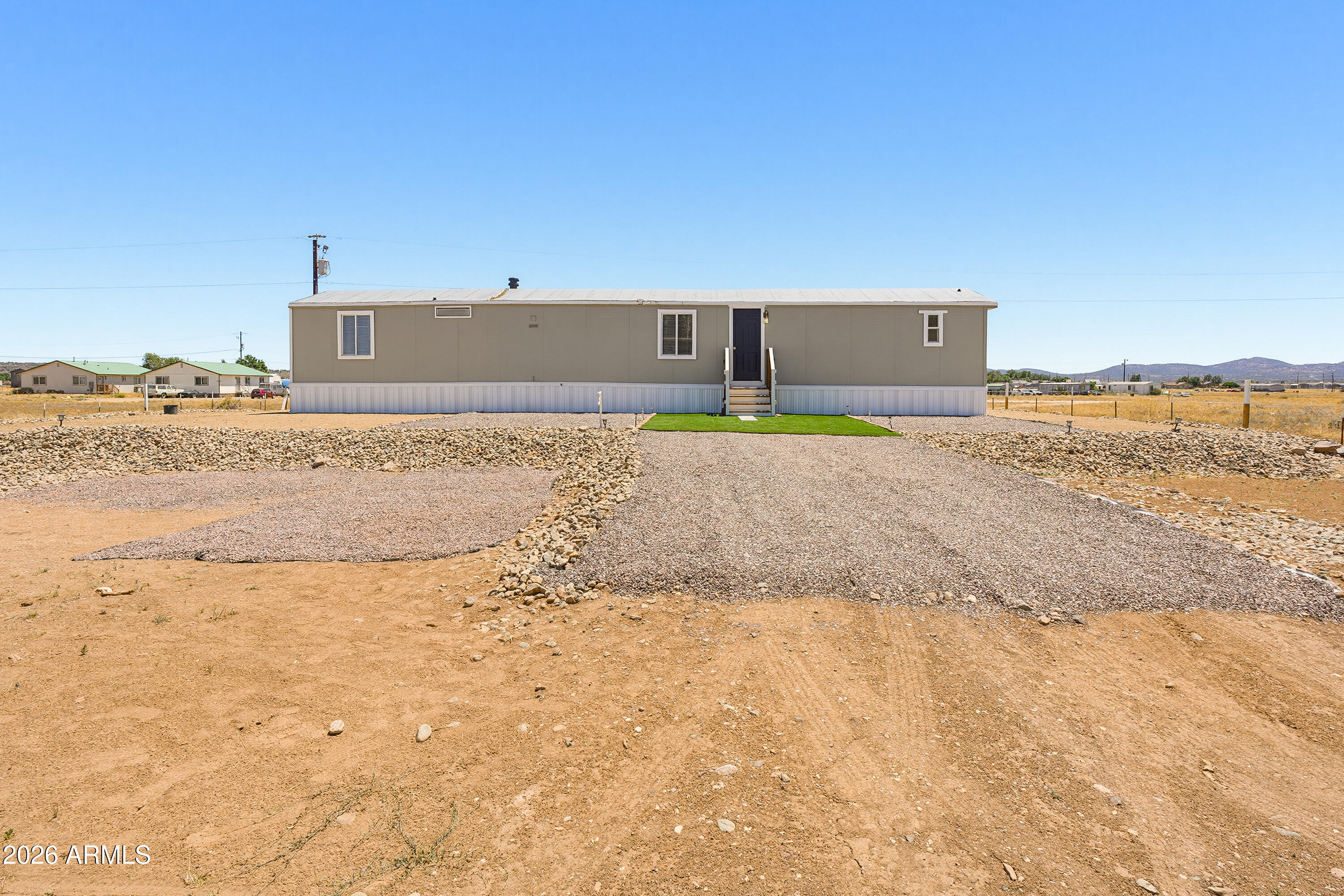 Welcome to your new home in the country! This nicely remodeled 1994 manufactured home offers modern conveniences and peaceful living. Step inside to find a bright, fresh space with brand-new interior paint and beautiful mountain views right outside your window. Modern kitchen: Brand-new white kitchen cabinets, granite countertops, new stainless steel appliances, including a wine refrigerator, and open kitchen space. Upgraded major systems: New A/C unit, new heating, new hot water heater. Desert Front Landscaping: Clean, easy care rockscape, green artificial turf, wire fencing, very low maintenance required. Peaceful Country Atmosphere: Relaxing mountain views, quiet rural feel, plenty of fresh air, perfect place to escape to from the city noise.