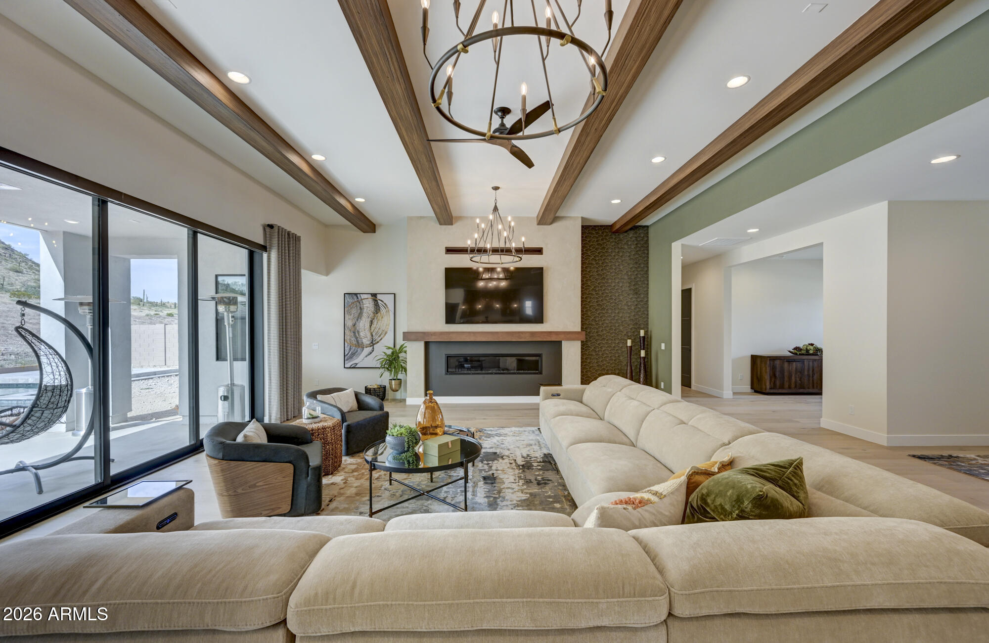 EASY TO SHOW! Welcome to this stunning 3-bedroom, + den, 3.5 bathroom home in Prelude at Oro Ridge, where breathtaking mountain views and luxurious upgrades create an exceptional living experience. Thoughtfully designed with both comfort and style in mind, this home offers elevated finishes throughout. At the heart of the home is a showstopping chef's kitchen featuring premium JennAir appliances, a built-in Sub-Zero refrigerator, triple ovens, a 6-burner gas cooktop with griddle, built-in wine refrigerator, as well as ice maker, sleek quartz countertops, a spacious walk-in pantry, and an oversized island with breakfast bar seating -- ideal for hosting gatherings or enjoy everyday meals. The open-concept great room impresses with striking beamed ceilings and a dramatic 16' multi panel sliding glass door that frames the breathtaking mountain views while flooding the space with natural light.  The expansive primary suite offers a serene retreat, complete with a spa-inspired ensuite bath featuring dual vanities, custom lighted mirror, a soaking tub, a beautifully tiled shower, and a generous walk-in closet. Bedroom 2 includes its own private ensuite bathroom, ensuring comfort and privacy for guests or family members. Bedroom 3 is filled with natural light from beautiful windows along with a well-appointed bathroom with a custom tiled shower, lighted mirror and stylish finishes. The den can be used as a home office, library, media room, playroom, fitness space, or even a guest retreat. Outdoors, your private backyard oasis awaits, highlighted by a stunning pool and ample space to design the ultimate outdoor retreat -- whether you envision a spa, outdoor kitchen, or tranquil desert escape!