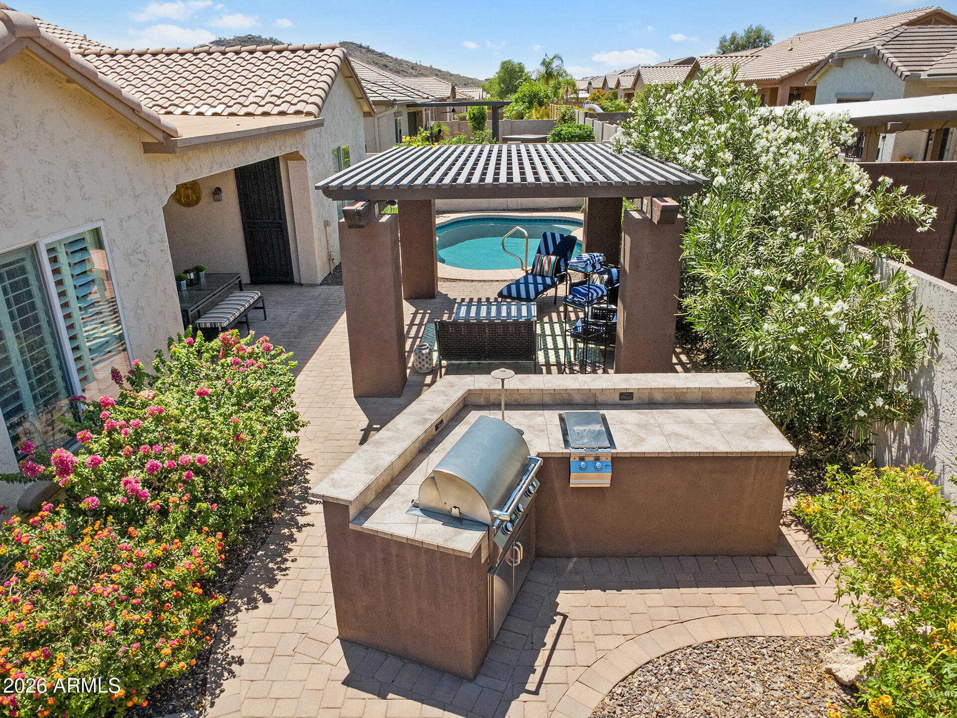 BACKYARD PARADISE WITH NEWLY ADDED POOL! With a charming courtyard entrance, this updated home features LUXURY vinyl plank flooring throughout the main living areas, plantation shutters & coordinated lighting fixtures throughout. The OPEN-CONCEPT layout offers a seamless flow from the formal dining area into the family room, highlighted by a statement stone fireplace, perfect for entertaining or everyday living. The family room opens to the kitchen showcasing rich cabinetry, an oversized center island with breakfast bar seating, abundant storage, dual wall ovens, a gas range, eat-in area & oversized walk-in pantry. The primary suite is generously sized with backyard access & an ensuite featuring dual vanities, a separate soaking tub, walk-in shower & large walk-in closet. Secondary bedrooms are nicely sized & share a full bath with double sinks & a shower/tub combination. Step outside to an entertainer's dream backyard featuring a NEWLY installed sparkling self-cleaning pool, large stone fireplace, expansive putting green, covered patio, gazebo & built-in BBQ. Located on a CORNER lot with MOUNTAIN VIEWS in a community with parks & playgrounds, just minutes from Inspiration Mountain School, I-17 access, shopping, dining & recreation.