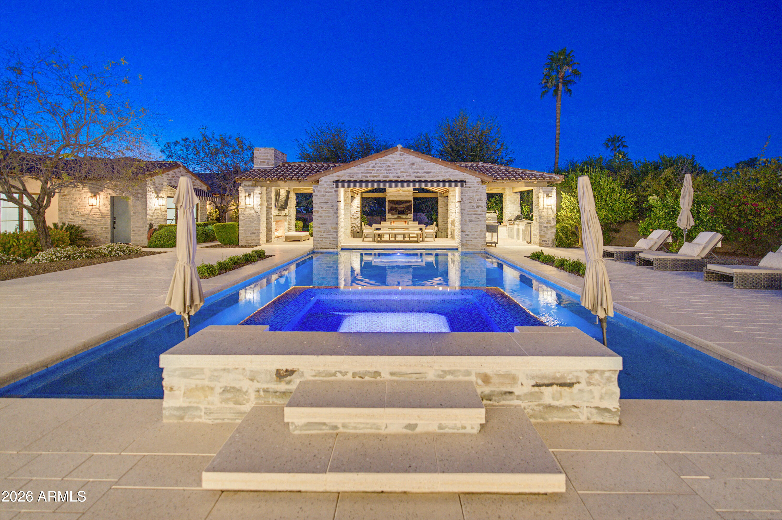 Completed in late 2023, this stunning 7,140-sq-ft contemporary estate sits on 1.19 acres in a quiet cul-de-sac with captivating Camelback Mountain views. The home offers 6 ensuite bedrooms and 8 bathrooms, blending luxury with livability. Expansive glass walls frame a lush, private backyard featuring a resort-style pool, spa, and an impressive pavilion with outdoor kitchen, BBQ, and smoker. A rare combination of modern elegance, privacy, and premier Paradise Valley location. This newly built Paradise Valley masterpiece delivers exceptional design, craftsmanship, and scale. Towering ceilings, natural light, and seamless indoor-outdoor flow define the main living spaces. The chef's kitchen features top-tier appliances, custom cabinetry, and a large butler's pantry. Every bedroom is a private retreat with a spa-style ensuite and generous storage. The grounds are equally impressive, with mature landscaping, extensive patios, and a resort-worthy outdoor pavilion equipped for full culinary entertaining. Set on over an acre in one of PV's most desirable cul-de-sacs, the home combines tranquility, views, and luxury living at its highest level.