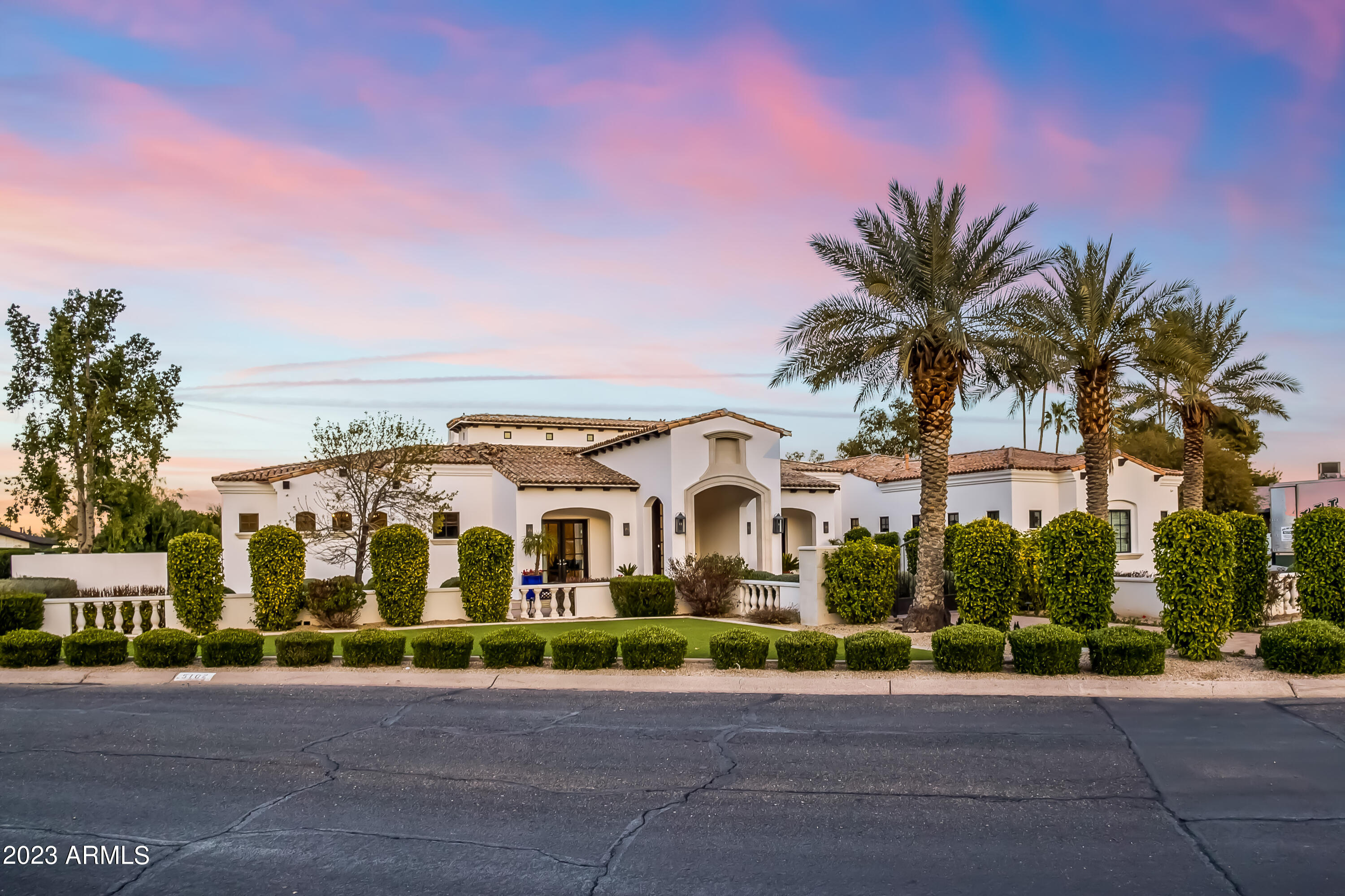 At the base of mummy mountain just north of Paradise Valley Country Club lies this immaculate Santa Barbara contemporary crafted by Regal American Homes, the premiere ultra luxury builder in Arizona. Soaring ceilings, multiple indoor outdoor spaces, sprawling patio, pool and grassy play yard. Large privately gated extra height garage spaces and additional RV parking, split floorplan with primary with his and her toilets and closets, four en-suites and bonus den/ play room. Breakfast, dining and giant eat in kitchen/ bar. Formal, den and indoor outdoor living room. CCC best school district in Arizona with schools minutes from the house. Quiet round about street of friendly neighbors. Privacy and luxury combine in this truly lush palm tree lined resort style entertaining estate.