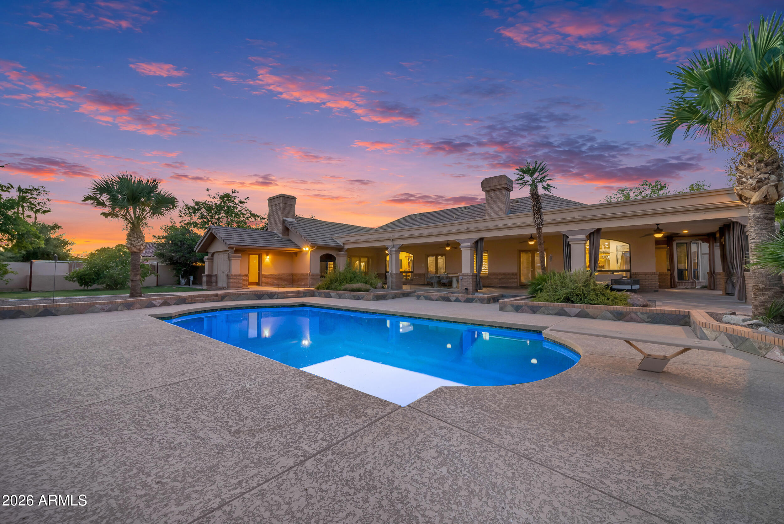 Prestige meets paradise in this rare Warner Estates gem, famously the former home of legendary ASU Football Coach John Cooper. Nestled on a sprawling, oversized interior corner lot, this estate commands attention from the start with a beautiful front courtyard and a striking, custom oversized iron door. Step inside to be absolutely floored by the architectural oak beams and soaring wood ceilings that crown the living room and eat-in kitchen. Living room features a beautiful, tiled beehive fireplace. Rich, polished slate and warm wood flooring flow seamlessly throughout the home, a family room anchored by a custom wood entertainment center, into a massive formal dining room, and private den, or game room. The designer kitchen is a chef's culinary dream, showcasing large islands cascaded with premium Jurassic Granite. Built for ultimate comfort and multi-generational luxury, the home features 3 on-suites with private bath among its bedrooms, a spectacular primary suite complete with a cozy raised hearth wood-burning fireplace and private ensuite bathroom walk-in surround tile shower and soaking tub. Car enthusiasts and hobbyists will love the rare 3-car extended length garage, providing massive storage and vehicle space. The resort-style backyard is a true private sanctuary, a diving pool, an extended covered back patio for seamless outdoor entertainment, a dedicated garden area, and a highly convenient outdoor pool bathroom. With so much more to see, this legendary Tempe estate is an absolute must-view to fully appreciate its scale and luxury.