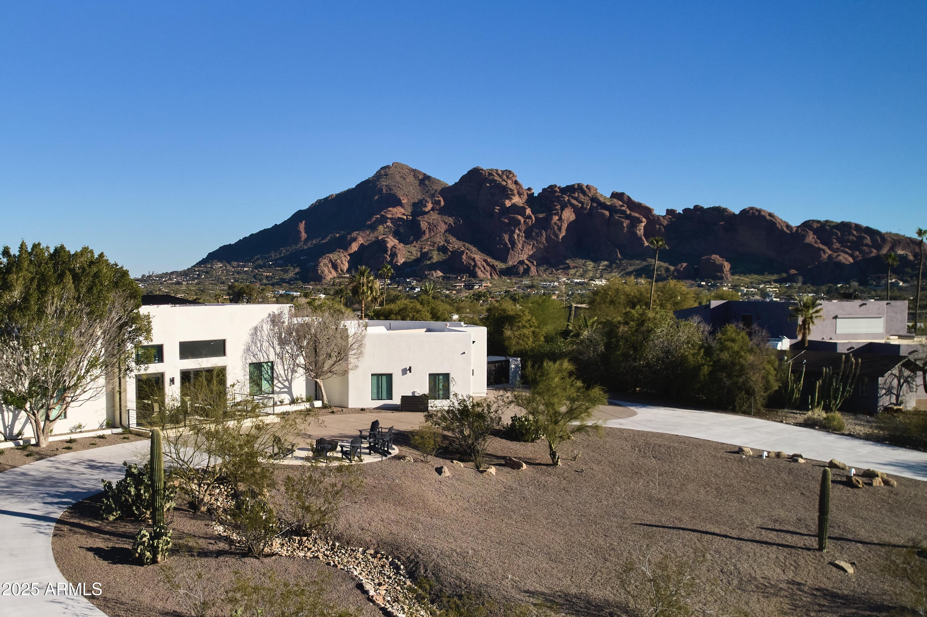 Perched on a private 1-acre hillside lot, this fully reimagined 5-bedroom, 4.5-bath luxury retreat delivers the ultimate Paradise Valley lifestyle with panoramic views of Camelback Mountain, Mummy Mountain, and sparkling city lights. Completely remodeled in 2024, the 4,138 sq ft residence blends sophisticated design with modern convenience—move-in ready and meticulously curated. Inside, soaring 14' ceilings, expansive glass doors, and custom finishes create a light-filled, elegant atmosphere. The split floor plan offers dual primary suites, each with a spa-like bath and soaking tub, while the gourmet kitchen serves as a true showpiece with two oversized islands, a butler's pantry, Monogram appliances, and a built-in Wolf coffee makerperfect for entertaining.

Resort-style living continues outdoors with a Pebble-tec pool with baja shelf and spa, a cold plunge, infrared sauna, firepit, and turf play areas, all designed for seamless indoor/outdoor living through accordion doors that open to both the backyard and a view-filled front patio.

Smart-home automation, advanced security, and ample parkingincluding RV/boat accesscomplete this one-of-a-kind property. With unmatched design, expansion potential, and all furnishings available for sale, this hillside estate is more than a homeit's an experience.