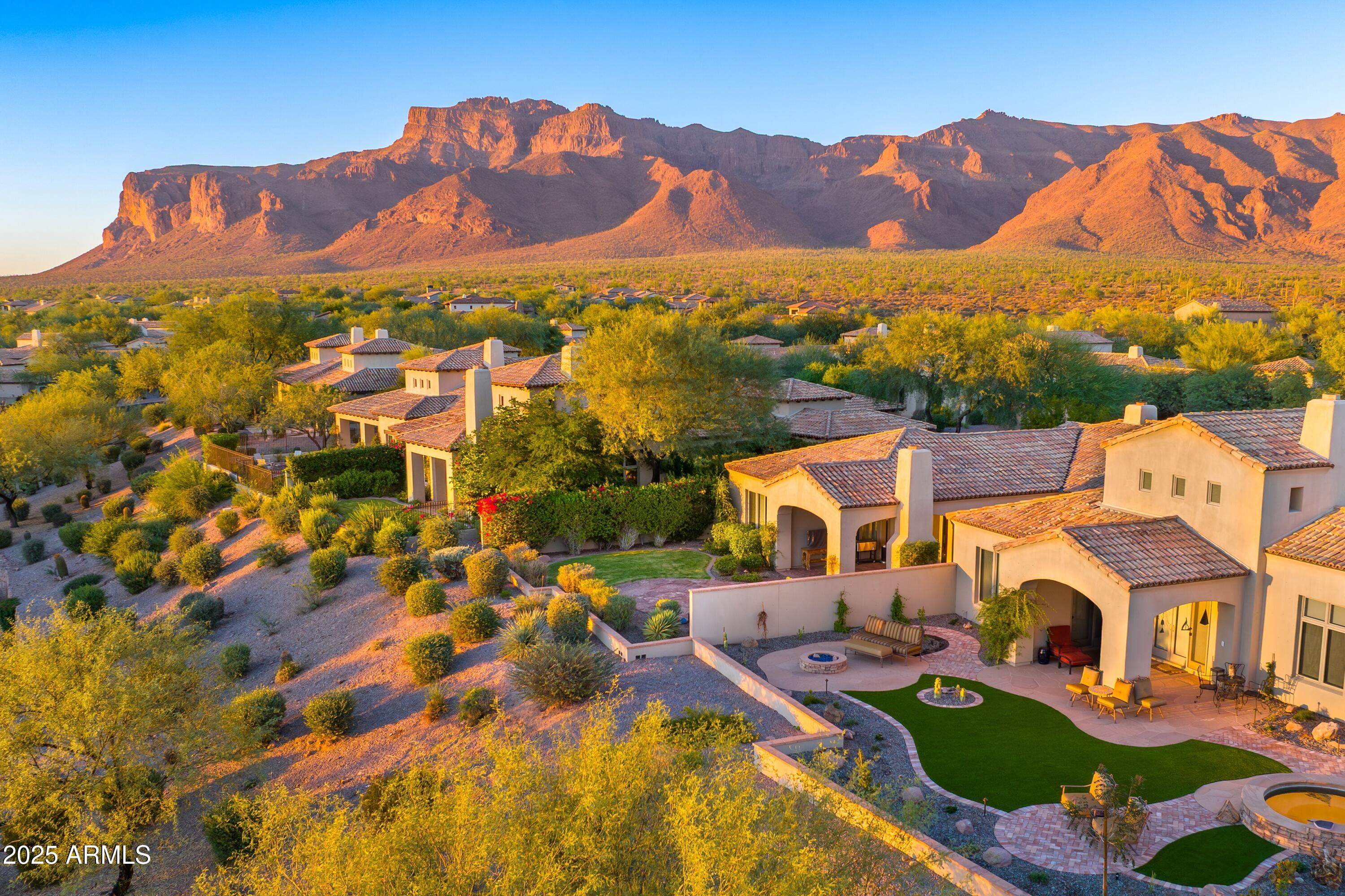 ARGUABLY THE BEST CITY LIGHT VIEWS IN THE ENTIRE COMMUNITY! Private backyard heated in-ground spa & waterfall! Offered furnished minus personal items & those on the exclusion list. Private Lyle Anderson community w/36 holes of Nicklaus designed golf, fully amenitized country club, 24/7 guard gated, past home to 8 nationally televised golf events on the Champions & LPGA tours in peaceful/no traffic Gold Canyon, Arizona' best kept secret. Less than 35 minutes to Sky Harbor & 20 minutes to Mesa Gateway. Beautifully designed upgraded villa w/tasteful decor, wood floors, Viking appliances, lock & leave--ready to move in! Quiet streets, no traffic. Golf, fitness center w/classes, tennis, pickle ball, bocce ball, fine dinning. Golf Club and Social Memberships under separate agreement with golf club ownership. Villa gently lived in--original owners, seasonal residents. ONLY TRUE 36-HOLE PRIVATE GOLF & COUNTRY CLUB IN CENTRAL ARIZONA. Primary bedroom with city light views. Wood casement windows, solid core knotty alder doors, Emtec hardware. Granite counters, kitchen island, farm sink, breakfast bar, walk-in pantry, built-in microwave, knotty alder cabinetry, plantation shutters. Upgraded lighting fixtures, wood beams ceilings, interior great room and backyard natural gas fireplaces, flagstone and paver patios, Kohler bath fixtures. Third bedroom has two twin beds and armoire easily converted to an office or den. Built-in natural gas BBQ. Only one traffic light separates residents from the Atlantic and Pacific Oceans. Where else? Nowhere else but here!