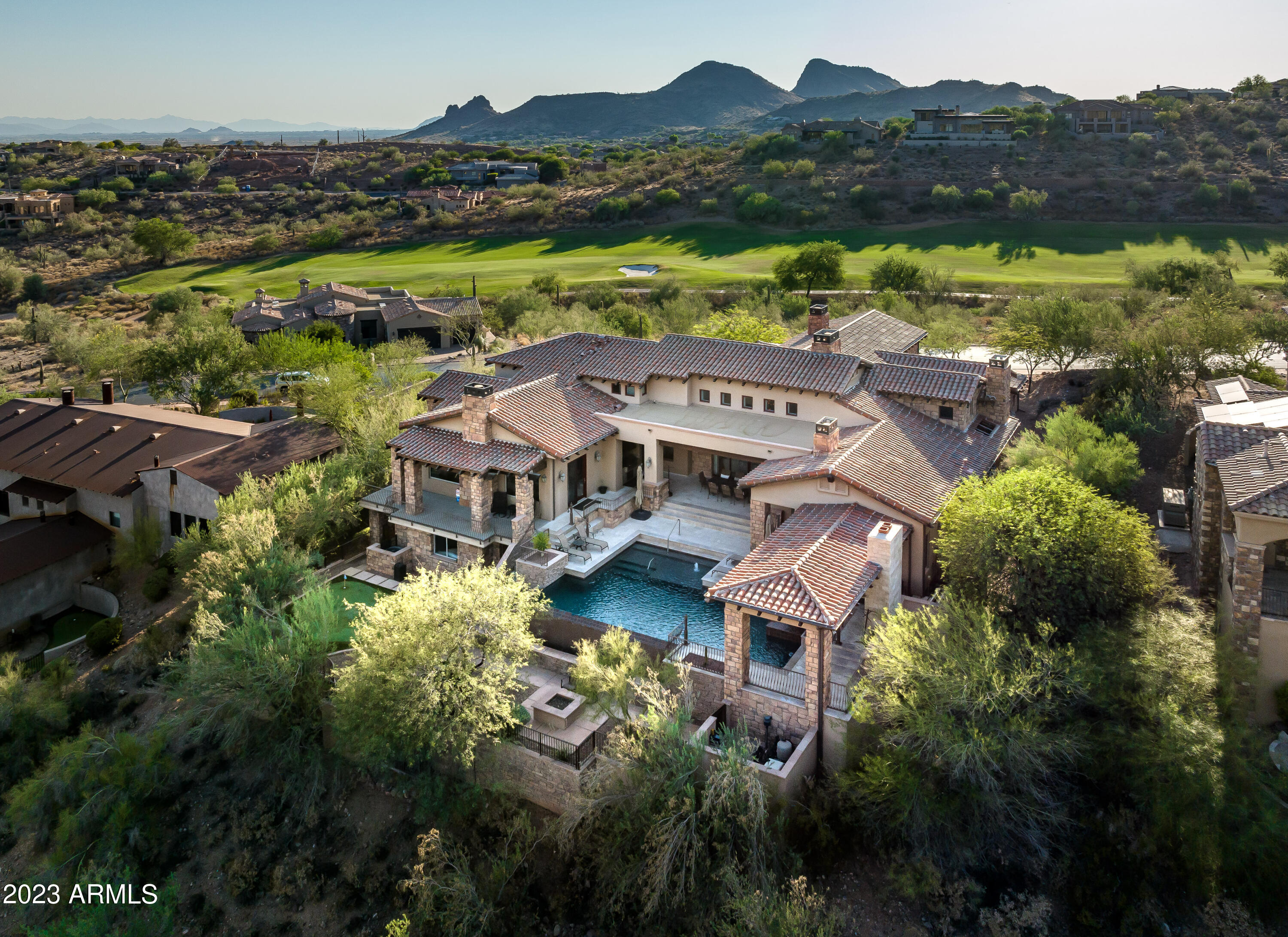 Welcome to your dream home located in the exclusive and prestigious Firerock Club, where LUXURY and PRIVACY blend seamlessly. Nestled within the secure confines of a private, guard-gated community, this residence offers an unparalleled living experience that will captivate your senses and elevate your lifestyle.

As you enter through the grand entrance, prepare to be greeted by an awe-inspiring sight. A magnificent retractable door beckons you to step inside and witness the magic that lies beyond. As the door glides open effortlessly, it reveals a deep patio that seamlessly merges with the interior, creating a harmonious flow between indoor and outdoor living spaces.

Behold the stunning negative edge pool, where the sparkling water seemingly cascades into the horizon. Set against a backdrop of breathtaking views, this oasis of tranquility invites you to indulge in moments of pure relaxation and serenity. Imagine lounging by the pool, basking in the warm Arizona sun, and being mesmerized by the picturesque vistas that stretch as far as the eye can see.

The interior of this remarkable abode exudes elegance and sophistication at every turn. High ceilings adorned with gorgeous wood beams create an atmosphere of grandeur and spaciousness. With 6 bedrooms and 5.5 bathrooms, there is ample room for your family and guests to unwind and find their own sanctuary within this haven of luxury.

Escape to the movie theater for an immersive cinematic experience or retreat to the executive office, where you can find solace while attending to business matters. The stunning gourmet kitchen is a culinary enthusiast's delight, featuring big double granite islands that provide ample space for meal preparation and entertaining. Equipped with a Thermador Professional Range and custom hood, this kitchen is a chef's paradise.

The formal dining room, overlooking the lush golf course and majestic mountains, sets the stage for memorable gatherings and elegant soirées. It's the perfect setting to create lasting memories with your loved ones and esteemed guests.

For those seeking privacy and exclusivity, the lower level of this magnificent residence is dedicated to accommodating guests in style. Complete with a full kitchen, two bedrooms, and a game room, your visitors will feel like royalty in their own private retreat. An elevator ensures easy access and convenience for all.

The backyard is a true oasis for outdoor entertaining and leisure. Practice your golf skills on the putting green, enjoy the warmth and ambiance of two gas fireplaces, or host unforgettable barbecues using the built-in grill. The inviting pool and spa provide the perfect respite on hot summer days, while the expansive patios offer ample space for al fresco dining and socializing.

This remarkable home is an embodiment of luxury, elegance, and privacy. Located in the prestigious Firerock Club, it presents a rare opportunity to embrace a lifestyle that is nothing short of extraordinary. Don't miss your chance to make this exquisite residence your own and experience the epitome of refined living.