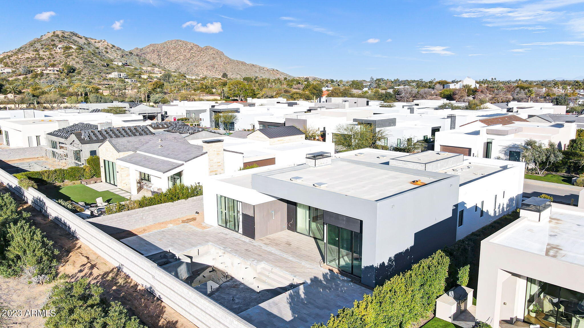 Welcome home to Azure by Shea Signature—luxury living that masterfully combines a spectacular natural backdrop with all the nuances of a top-tier gated community. Designed by the world-renowned PHX Architecture and featuring captivating interior design by Ownby Design, this brand-new modern home is located on a premium homesite, providing a single-level split floor plan, unparalleled Camelback views and sophisticated, sleek finishes. With every detail thoughtfully considered and addressed to perfection, this one-of-a-kind offering is truly paradise. Inside the 3,646-square-foot home, beautiful sunsets and gorgeous mountain views blend harmoniously with modern and transitional architecture. Three expansive bedrooms, three-and-a-half bathrooms and an office are situated around open floor-plan living spaces for dining, relaxing and entertaining. The primary suite presents gorgeous Camelback views, a beautiful bathroom and a walk-in closet that leads to the laundry room. The spacious chef's kitchen features Gaggenau appliancesincluding a wine fridge and under-cabinet fridge drawerCaesarstone quartz countertops and a separate prep kitchen space ideal for hosting. Floor-to-ceiling sliding glass walls integrate seamlessly with the yard for coveted indoor-outdoor living. In the south-facing backyard, a gorgeous heated custom pool with a waterfall edge, spa, firepit, infrared patio heaters and immaculate landscaping designed by Creative Environments provide gorgeous transitional living spaces. This exclusive, luxury community of transitional and modern architecture new build homes provides immediate proximity to the Ritz Carlton Hotel and the Fendi Estates, with new high-end shopping planned nearby. Embrace the beautiful and imagine the possibilities at Azure.