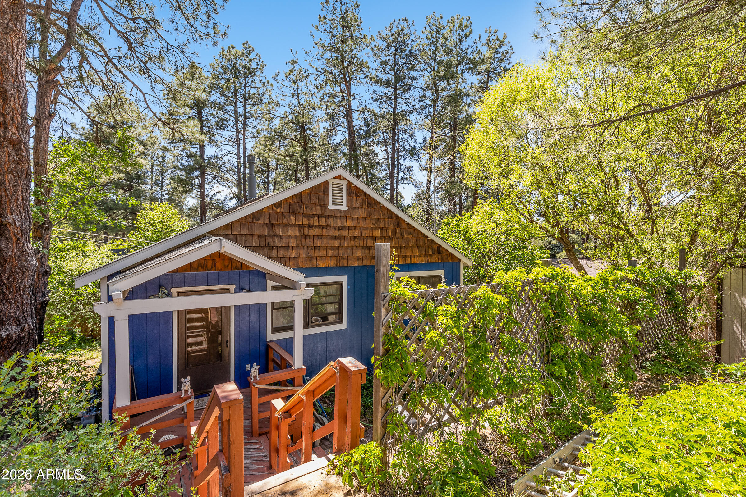 Fresh mountain air, towering ponderosa pines, and direct access to adventure--this Mountainaire retreat is made for those who love the outdoors. ATV enthusiasts will appreciate nearby trail access, while hikers and nature lovers can step into the National Forest right from the neighborhood. Inside, a detailed wood entry door welcomes you to an open floorplan with vaulted ceilings, skylights, abundant natural light, and a stunning flagstone-backed fireplace. Outside, mature pines provide cool shade, a storage shed for gear, with space for a garden and a trellis fence with privacy vines. Enjoy a quiet, secluded setting just minutes from a local tavern and corner store. Rental-friendly and full of mountain charm.