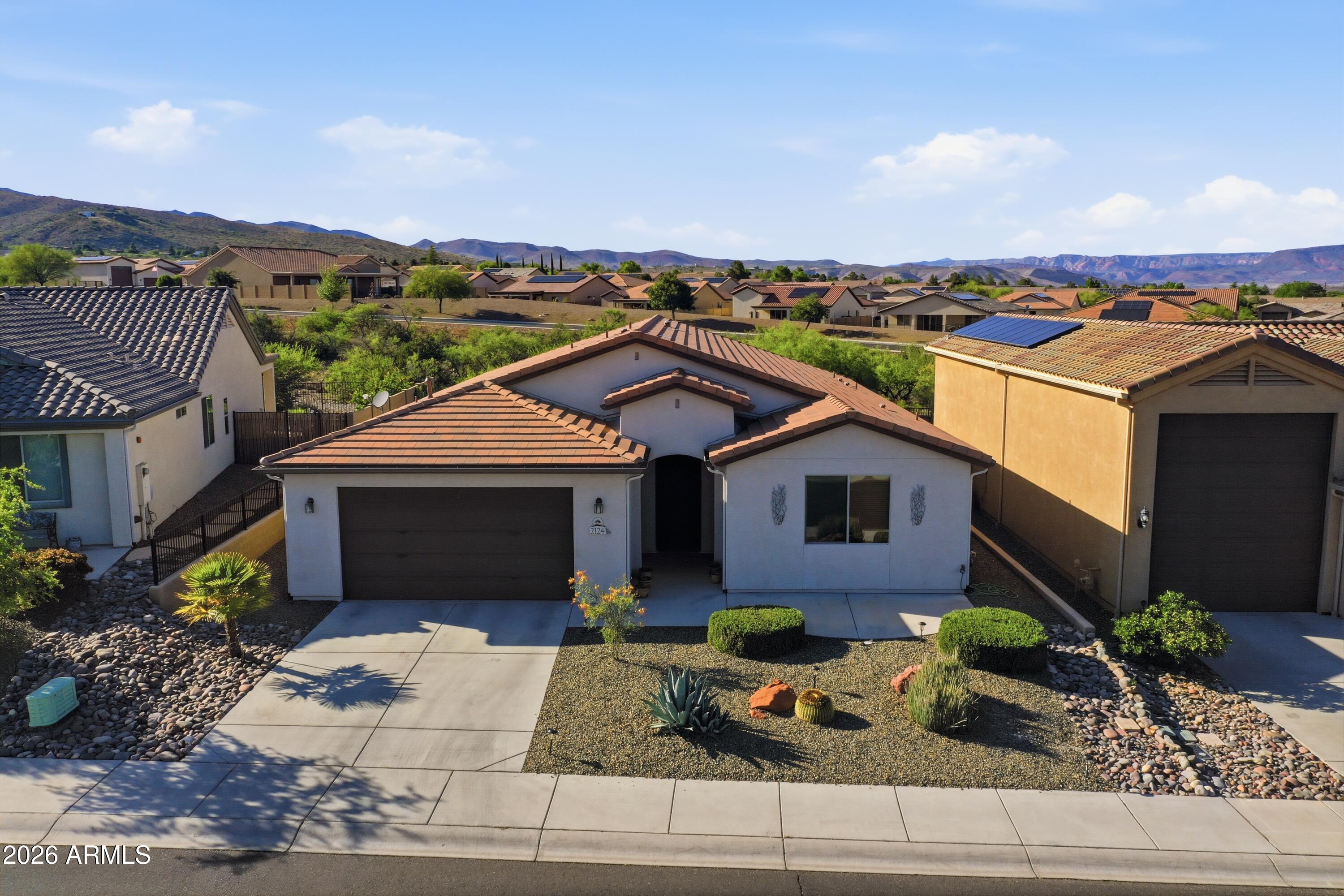 Tucked at the base of Mingus Mountain in the desirable Mesquite Hills Subdivision, this beautifully maintained home delivers views, space, and elevated Northern Arizona living. The expansive great room with 9' ceilings flows seamlessly into a stunning kitchen featuring an extended island and gorgeous granite throughout--perfect for gathering and entertaining. Wood plank tile floors add warmth and durability. Step outside to a low-maintenance, fully fenced backyard complete with a large covered patio, step up paver deck, and built-in BBQ kitchen--ideal for enjoying Arizona sunsets. The charming front coffee patio offers a welcoming space to relax and connect with neighbors. Minutes to Old Town Cottonwood, Clarkdale, and Sedona--this is lifestyle and location in one.