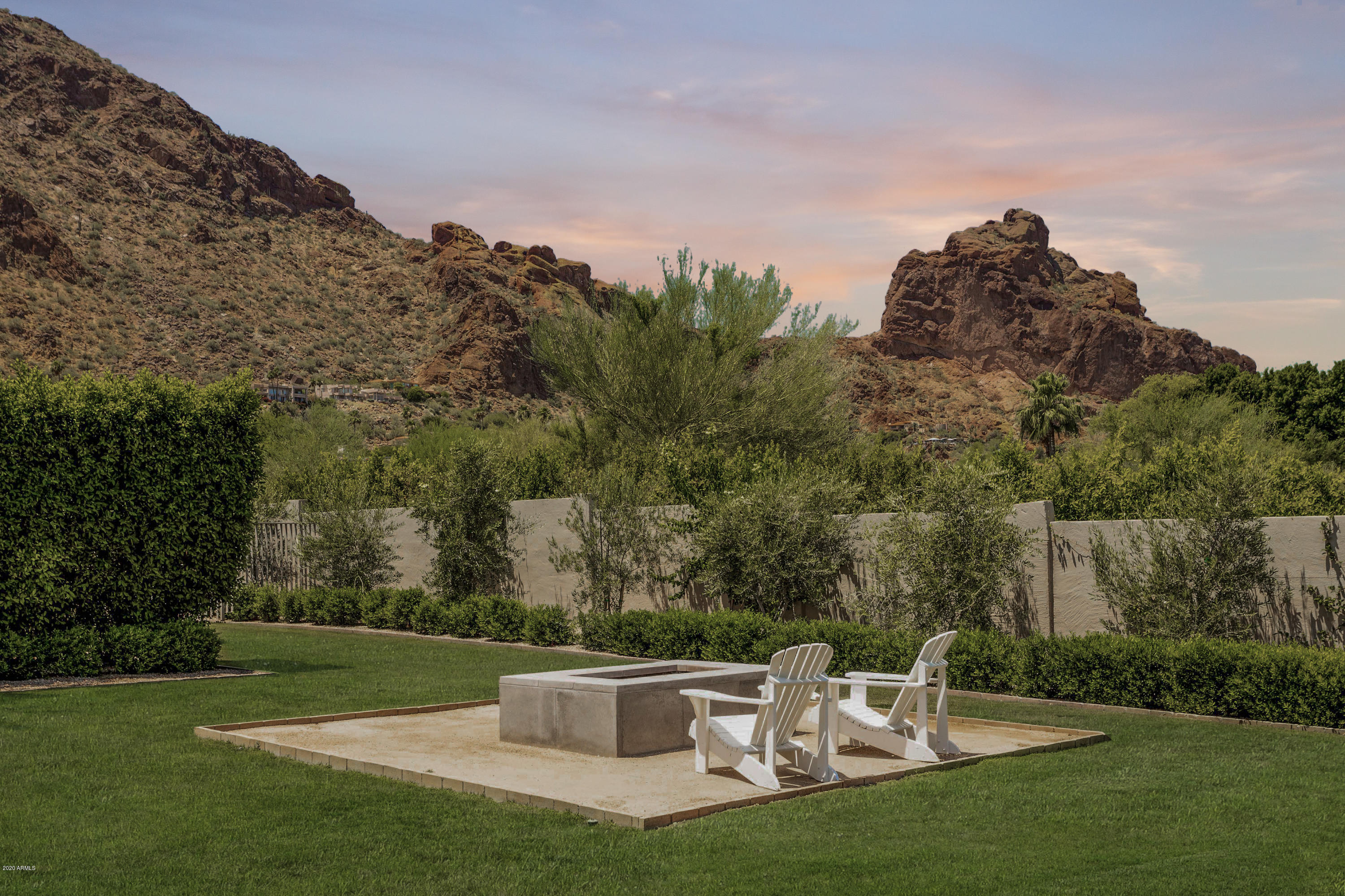 Beautiful hidden gem with the most captivating views of Camelback Mountain and the Praying Monk. Camouflaged behind tall electrical gate is a bright, timeless home with unparalleled design and finishes.  Originally designed by Bernie Gonzalez and completely renovated to feature 3 generously sized bedrooms, 3.5 bathrooms, a stunning office and a beautiful open concept living space. White washed wood beams and 15ft ceilings capture a breathtaking view.  Gourmet kitchen with custom range hood, white slab marble countertop and ample storage space is sure to impress.  Exquisite outdoor living space with spacious covered patio space featuring gas fireplace and tranquil water feature. Superb landscaping with large grassy area, mature trees, rose and vegetable garden and sitting area with firepit. The home also offers a three car garage plus lifts, easily storing six vehicles. This one of a kind property will not be on the market for long!