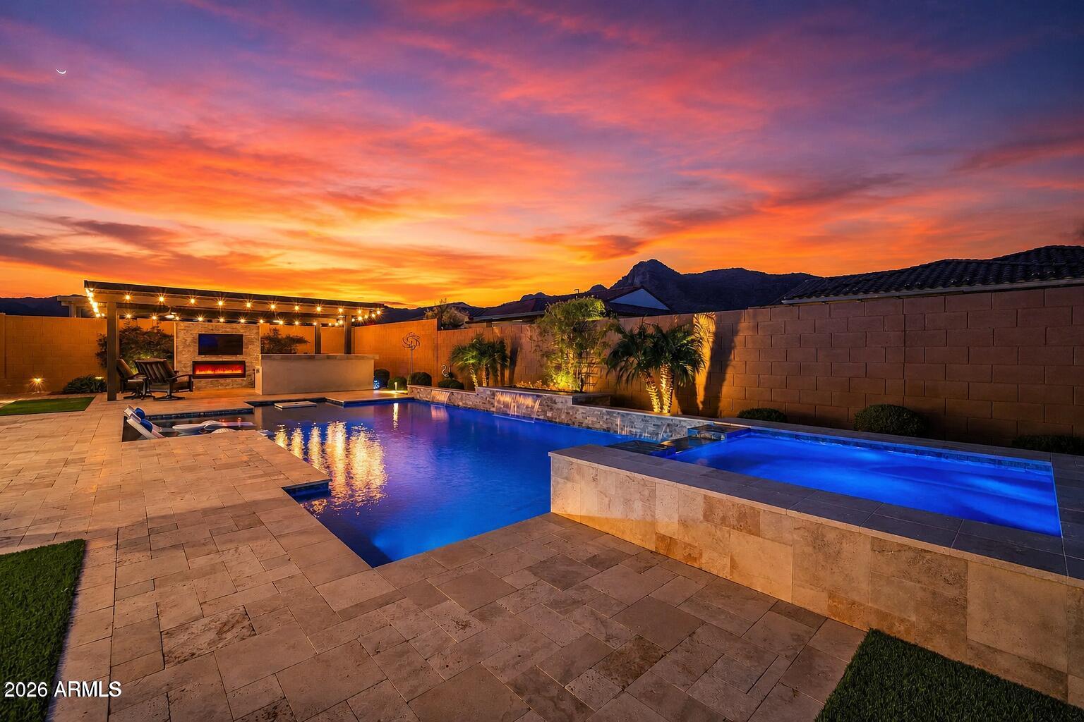 YOUR OPPORTUNITY TO OWN A BETTER-THAN-NEW DREAM HOME in a new yet established neighborhood--without months of living in a construction zone or waiting for the punch-list repairs that often come with a brand-new home. Every detail has already been meticulously completed, from OVER $625,000 IN BUILDER AND OWNER UPGRADES to the home's carefully planned orientation that helps keep the pool warm while creating a shady backyard oasis with a comfortable covered patio featuring ceiling fans and a custom built-in sound system, all while minimizing direct afternoon sun on the rear of the home. Mountain views and privacy complete this stunning resort-style residence in the coveted 55+ Victory Community. Offering abundant space for entertaining along with a quiet and peaceful retreat, this home delivers the best of both worlds: a rare blend of privacy, scale, and refined craftsmanship.

A welcoming courtyard entry opens to a bright, thoughtfully designed floor plan featuring all ensuite bedrooms. The kitchen is a true entertainer's delight, showcasing custom lighting, dual ovens, a dual-drawer beverage refrigerator, wine fridge, built-in filtered ice maker, and an oversized pantry complete with a prep sink, exceptional storage, and generous workspace. Outdoor living truly shines! The spacious backyard features a custom-designed pool with striking water and fire features, along with a covered outdoor kitchen complete with a TV and ample seating--perfect for relaxing or hosting gatherings year-round. In-pool seating offers the perfect place to cool off while enjoying your favorite beverage.

Additional highlights include high-end automated blinds, solar screens, indoor and outdoor speakers, and a hard-wired security system for added convenience and peace of mind. The craft room is outfitted with custom cabinetry for effortless organization and includes a built-in Murphy bed for guests. Rounding out the home is a dream garage featuring an upgraded and extended work area, custom cabinetry, elevated storage racks, and epoxy flooring.

While this home is your private OASIS, Victory at Verrado is a place to truly live, known for its welcoming neighbors and exceptional sense of community. Activities and social opportunities abound with newly expanded pickleball courts, tennis, bocce ball, a lap pool, three relaxation pools, a hot tub, sauna, and a well-appointed fitness center. Need to unwind? Enjoy the spa or grab a bite to eat while taking in the incredible views. The Crafts with a View studio offers numerous artistic classes and creative opportunities. Clubs fit nearly every interest, and social gatherings--including comedy nights, live music, and poolside events--fill the calendar year-round.