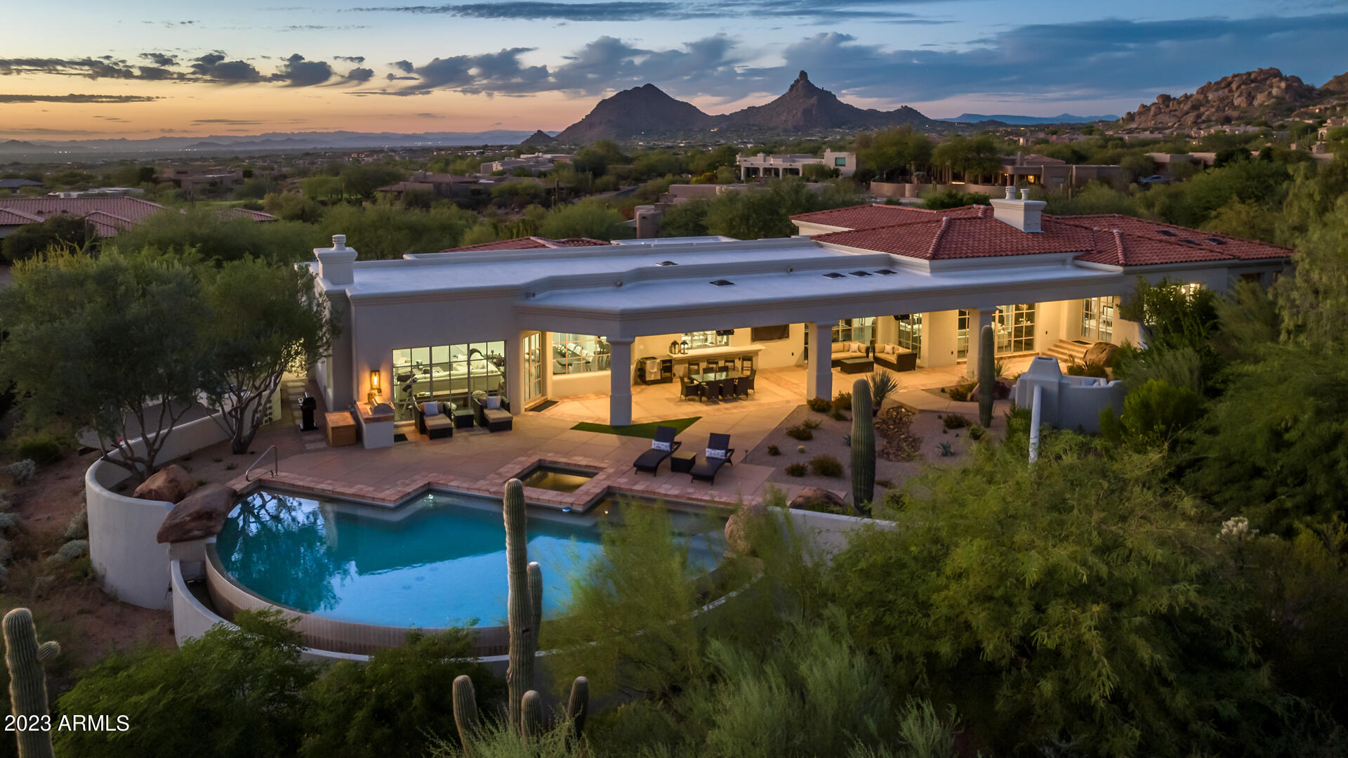 Stunning Salcito Custom, Santa Barbara style home with beautiful panoramic views of Troon Mountain, McDowell Mountain Range and Pinnacle Peak from both the front and rear of the home.  Located in the exclusive neighborhood of Glenn Moor in Troon Village, this home offers 4 bedrooms and 4.5 baths in over 5,600 square feet. Beautifully stained herringbone tile throughout the main living spaces with complimentary hardwood flooring in all the bedrooms. This home boasts 3 custom limestone fireplaces in the Great Room, Family Room and Master Bedroom as well as coffered ceilings with exposed beams adding to the warmth of this elegant space. The gourmet chef's kitchen, recently updated, features white cabinets, an updated pantry, pass-through window to outside bar area and stainless steel Wolf appliances including an induction range with downdraft range hood, oven/convection steam oven, microwave and SubZero refrigerator.  Also included is a Miele dishwasher, Miele built-in coffee maker and ice machine. The Family Room, Great Room and Master Bedroom feature walls of beautiful windows offering magnificent views of the mountains and surrounding vegetation.....perfect for sunrises and sunsets. The split floor plan offers much needed privacy for the owners.  Enter the primary suite through french doors and enjoy an amazing fireplace, magnificent views and private entry/exit to the backyard living space. The primary ensuite features 2 bathrooms, his and hers, separated by a pass-through shower with Aremec steam, as well as a large soaking tub.  A custom closet and private gym complete the owner's wing. Adjacent to the owner's suite is the custom executive office with library featuring floor to ceiling built-in bookcases and matching credenza with LED under shelf lighting by Woodesign, a premiere wood design firm in the Valley.  All ancillary bedrooms feature ensuite baths and walk-in closets with bath 4 offering access to the pool area. The backyard living space includes a heated, negative edge pool with spa offering views of the McDowell Mountains and Troon Mountain. A gas fireplace with seating provides added ambiance to your outdoor living experience. A gated entry with large portico welcomes visitors to this home.  This home is fully automated by Control4 Home System allowing the homeowner to manage all interior/exterior lighting, audio, video, security, thermostats, motorized shades and garage doors. Upgrades include central whole house vacuum system by Element Central Vacuums, 3 new Carrier performance series HVAC and furnaces, Nest thermostats, 2 new gas water heaters, new security system, new garage doors with LiftMaster smart garage door openers accessible through owner's smartphone as well as new epoxy floor, whole house new tile and flat roof including all new skylights, exterior stucco repaired/painted and new interior paint. The pool equipment is also new, including 3 Jandy Pumps, a filter, Jandy heater and a pergola from Royal Covers to shade the pool equipment. Professionally decorated with new interior lighting and door hardware make this home a "must see."  Come see this extraordinary home and why Glenn Moor is truly the place to be.
 
The Glenn Moor Club includes a clubhouse, pool, tennis/pickleball court, and shuffleboard courts. The Troon Country Club sits just to the north of Glenn Moor and the Four Seasons Resort at Scottsdale Troon North is minutes away. World class hiking, including Pinnacle Peak Park and Tom's Thumb trailhead, along with exclusive shops and dining are in close proximity.