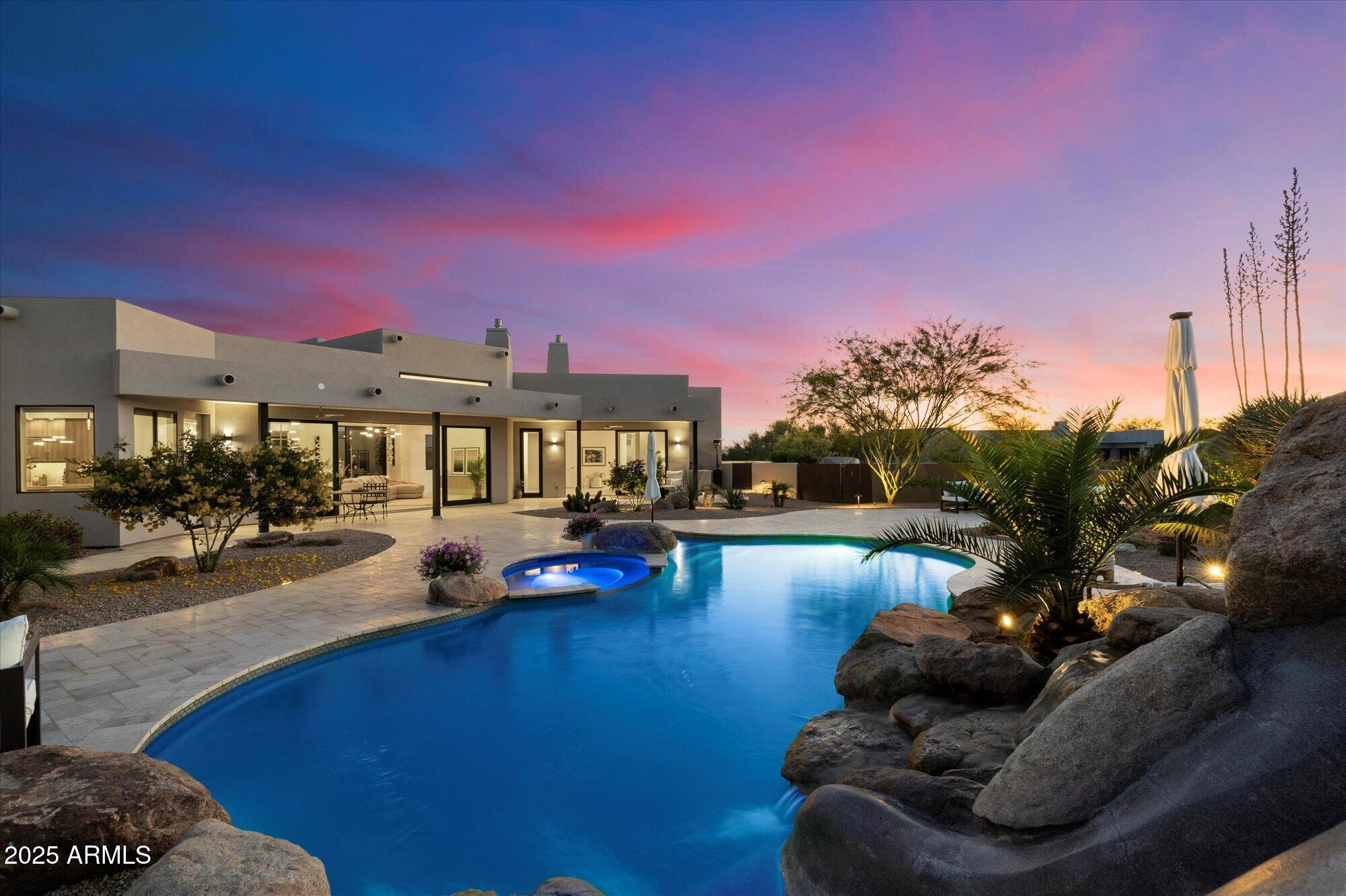 A modern sanctuary of luxury & design, this exceptional reimagined 2024 remodel is turn-key, offering the essence of a new home without the wait to build. Set on 1.5-Acres of privacy in North Scottsdale's coveted Pima Acres, with a 4-Car Garage & Stunning Unobstructed Views of the McDowell Mtns, Pinnacle Peak & City Lights. Every detail meticulously curated to rival nearby $5M+ custom homes, from striking architectural lines to a newly designed outdoor resort setting. A dramatic glass pivot door opens to soaring, light-filled spaces, new windows & walls of glass, seamlessly blending indoor elegance & outdoor entertaining. Thoughtfully designed, this exquisite home highlights a new kitchen, top-tier appliances & lavish full baths. Designed for today's effortless living, ready to be yours. INQUIRE ABOUT THE 2024 REMODEL SPECIFICATIONS for complete list of new Interior & Exterior features uncommon in most home remodels. This beautiful custom home is as close to a new home build as it gets.

The Gourmet Kitchen is a culinary sanctuary, outfitted with new Sub-Zero, Wolf appliances, sleek custom cabinetry & quartzite countertops. A new built-in coffee bar, separate wine & beverage area elevate the space for entertaining. 

A stunning Great Room, centered around a sleek linear fireplace wrapped in floor-to-ceiling marble - radiating warmth and refined elegance.

The Primary Suite is a true sanctuary, with breathtaking mountain views, a lavish spa retreat, and private access to an in-ground outdoor spa.

Four versatile bedrooms - perfect for family, guests, or a private retreat - along with a dedicated media room/home office, expansive laundry-mud room area, ensure the home is as functional as it is beautiful.

Equipped with the latest in smart home technology & convenience, including a Lutron Caseta smart lighting system, integrated surround sound speakers (indoors/out), SONOS-ready, 2 brand-new HVAC systems, a new Roof & an expansive View Deck, this home is designed for effortless living.

Step into the Resort-Style Backyard, where vibrant sunsets light up the sky beyond Pinnacle Peak & McDowell Mountain views. The newly renovated pool, 2 heated spas, waterslide & cascading waterfall provide the ultimate setting for relaxation. Entertain effortlessly with a built-in outdoor BBQ kitchen, new limestone paver patios throughout & lush new landscaping illuminated by dramatic low-voltage lighting at night.

The Oversized 1.52-acre Homesite offers not only serenity & privacy but also the rare potential for Future Expansion - be it additional living space, garages, sport courts. With split oversized 4-car garages (built-in storage cabinetry), this property effortlessly adapts to a range of lifestyle needs-whether you're seeking a refined downsizing opportunity, an elevated upgrade, or the perfect seasonal Arizona retreat.

Minutes to DC Ranch Marketplace, Grayhawk Golf Club, West World, Scottsdale Airpark, Scottsdale Quarter & Kierland, and the 101 Freeway - this home offers unmatched location to Scottsdale's premier shopping, dining, recreation opportunities.

Plan your private tour today - prepare to experience a beautiful new residence that transcends ordinary!