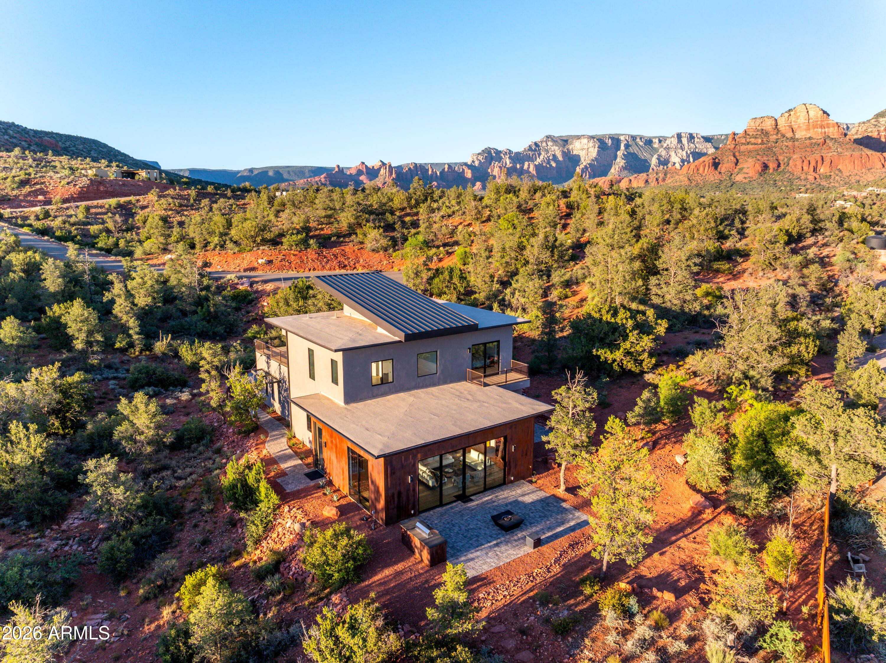 Stunning luxury home with unobstructed red rock views of Cathedral Rock in the prestigious Mystic Heights subdivision. Perched above Oak Creek and adjacent to National Forest, this 3,516 SF residence offers direct access to hiking trails and a rare blend of privacy, scenery, and convenience.
Situated on 1 acre, the home features 4 bedrooms, 5 bathrooms, and a 4-car garage. The open-concept floor plan is designed for seamless indoor-outdoor living, with expansive windows framing the surrounding red rock landscape.
The gourmet kitchen is equipped with top-of-the-line Thermador appliances, a large center island, and a custom walnut bar:ideal for both everyday living and entertaining. The primary suite offers a private outdoor retreat with hot tub & cold plunge. Upstairs, a spacious view deck captures panoramic red rock vistas. The outdoor terrace includes a built-in BBQ and gas firepit, creating an ideal setting for enjoying Sedona sunsets.

Located within walking distance to Oak Creek and nearby trail systems, and just minutes from Red Rock State Park, dining, shopping, and cultural amenities including the Sedona Performing Arts Center. High-speed Quantum Fiber internet (approx. 2GB per second download speed and close to 2 GB per second for upload speed).