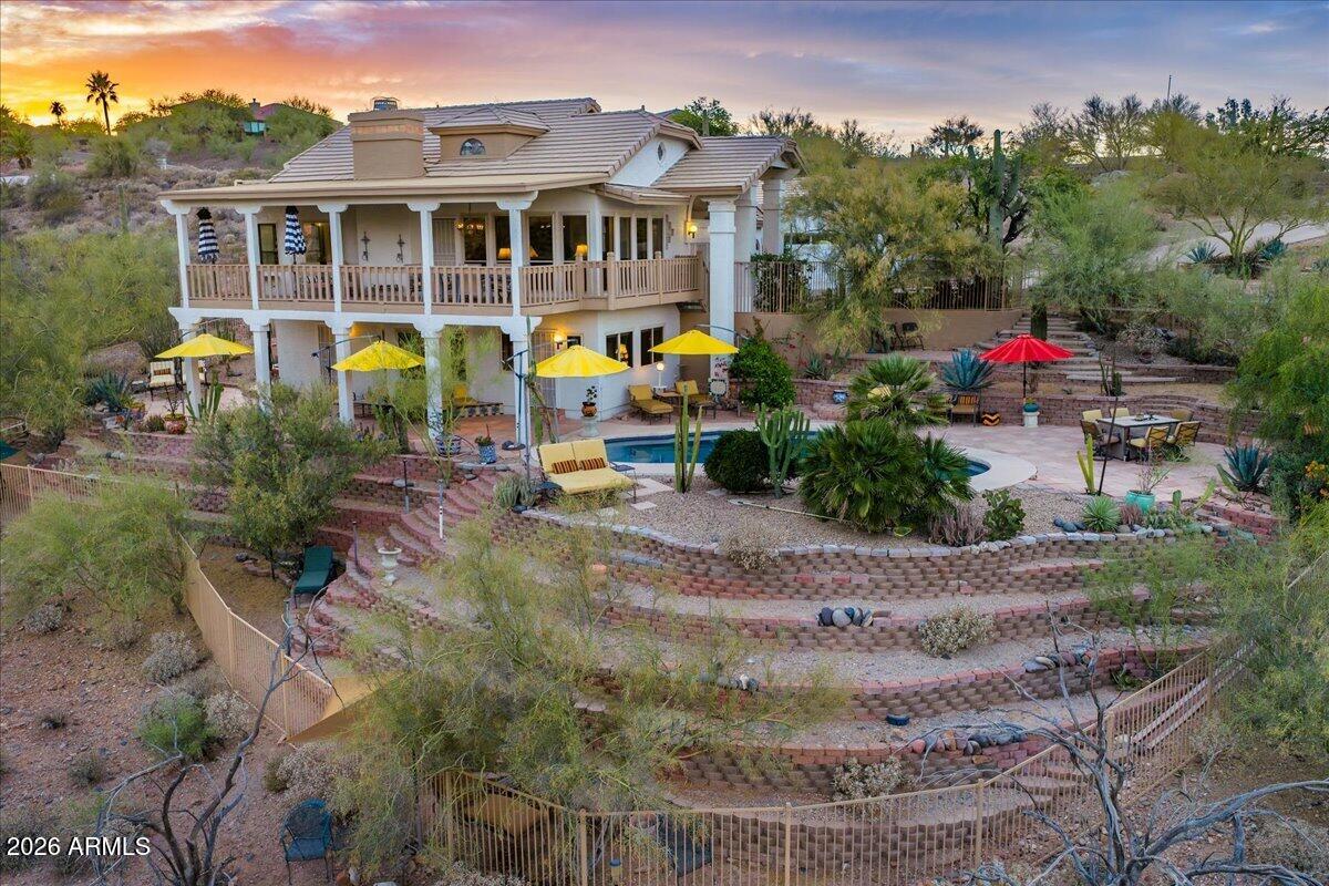 Architecturally unique and truly one-of-a-kind, this resort-style retreat is nestled on nearly an acre in the heart of Fountain Hills. Designed into a sloped desert setting with thoughtful terracing, the property allows multiple levels of outdoor living to be fully enjoyed. Featuring 3 bedrooms, 2 baths, a spacious primary suite with sitting area, and an inviting loft, the home offers soaring vaulted ceilings and light-filled interiors. Expansive mountain views, panoramic desert views and a natural wash bordering the property create an exceptional connection to nature, while the backyard features a sparkling pool, multiple seating areas, and serene spaces to enjoy the surrounding desert beauty.