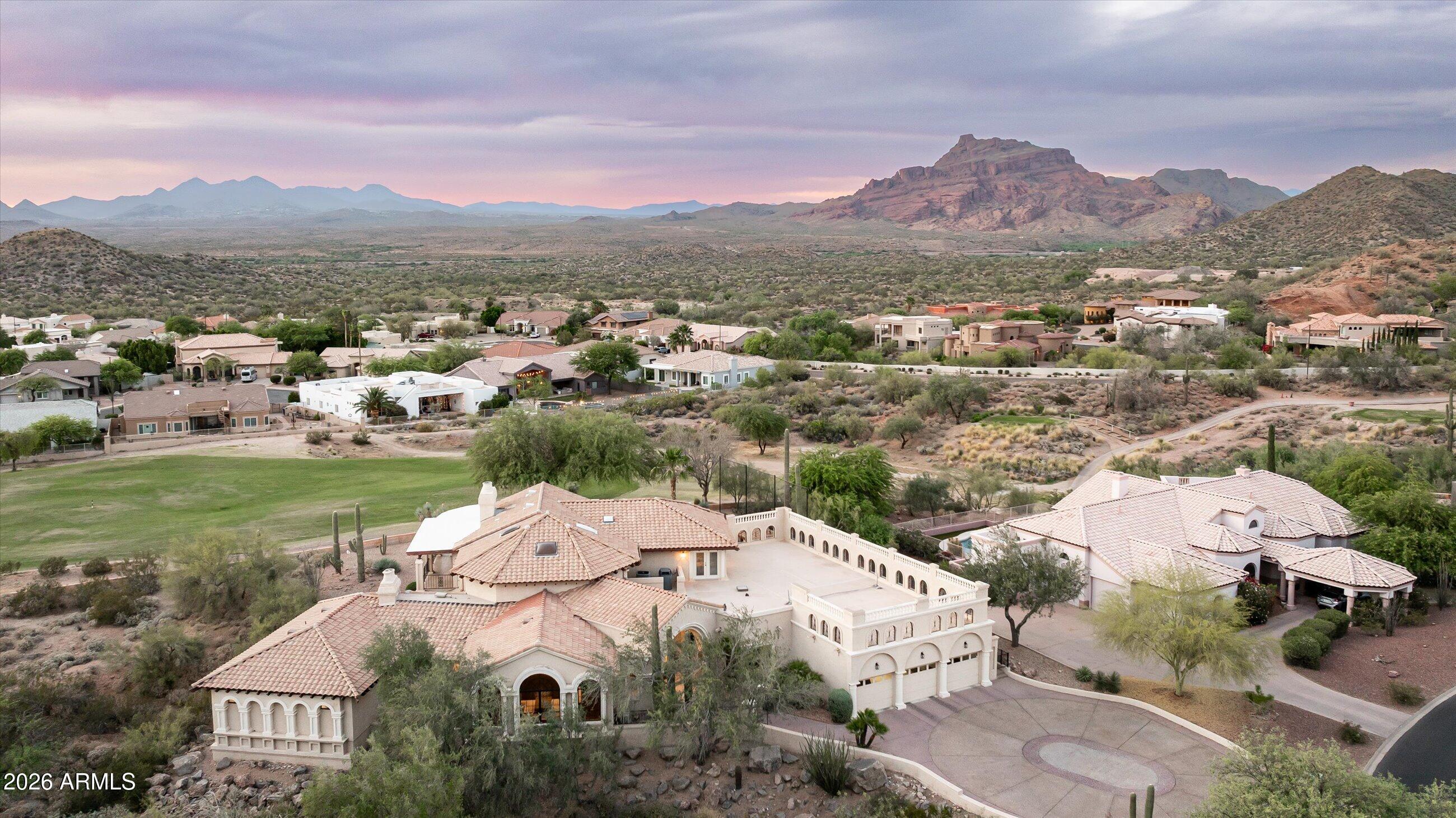 Experience elevated desert living in the prestigious Sky Mountain Estates, where luxury, privacy, and lifestyle come together on nearly ¾ of an acre.
This expansive 8,000+ square foot residence offers 6 bedrooms, 5 bathrooms, and a thoughtfully designed floor plan that blends grand-scale entertaining with comfortable everyday living. From the moment you enter, you're greeted by soaring ceilings, refined finishes, and a bright, open layout that seamlessly connects the main living spaces. The chef's kitchen features granite countertops, a large island, walk-in pantry, and flows effortlessly into multiple gathering areas, creating the perfect setting for hosting or relaxing. The home is loaded with amenities including a private guest quarters with separate entrance, library with built-ins, game room, loft, exercise/sauna room, and multiple fireplaces throughout. The split primary suite offers a private retreat with a sitting area, spa-like bath, and direct access to the backyard.
Step outside to your own desert oasis, complete with a private pool, built-in BBQ, multiple covered patios, and breathtaking mountain and city light views. The property sits on a premium golf course lot with north/south exposure, offering both privacy and scenic surroundings.
Beyond the home, the lifestyle here is what truly sets it apart. Enjoy a quiet, well kept neighborhood with amazing neighbors, access to a golf course and country club, and parks featuring playgrounds, pickleball courts, and wide open grassy areas for kids and pets. Outdoor enthusiasts will love the hiking trails within the community, as well as the newly paved and lit biking and walking paths along Power Road.
Conveniently located just 10 minutes from the Salt River and 25 minutes from Saguaro Lake with boat access, this home offers the perfect balance of luxury living and outdoor adventure. Families will appreciate the K-8 school within the neighborhood and the newly built ALA campus nearby.  Quick access to the Loop 202 makes getting anywhere in the Valley effortless.
This is more than just a home, it is a lifestyle defined by space, views, and connection to everything that makes Arizona living exceptional.