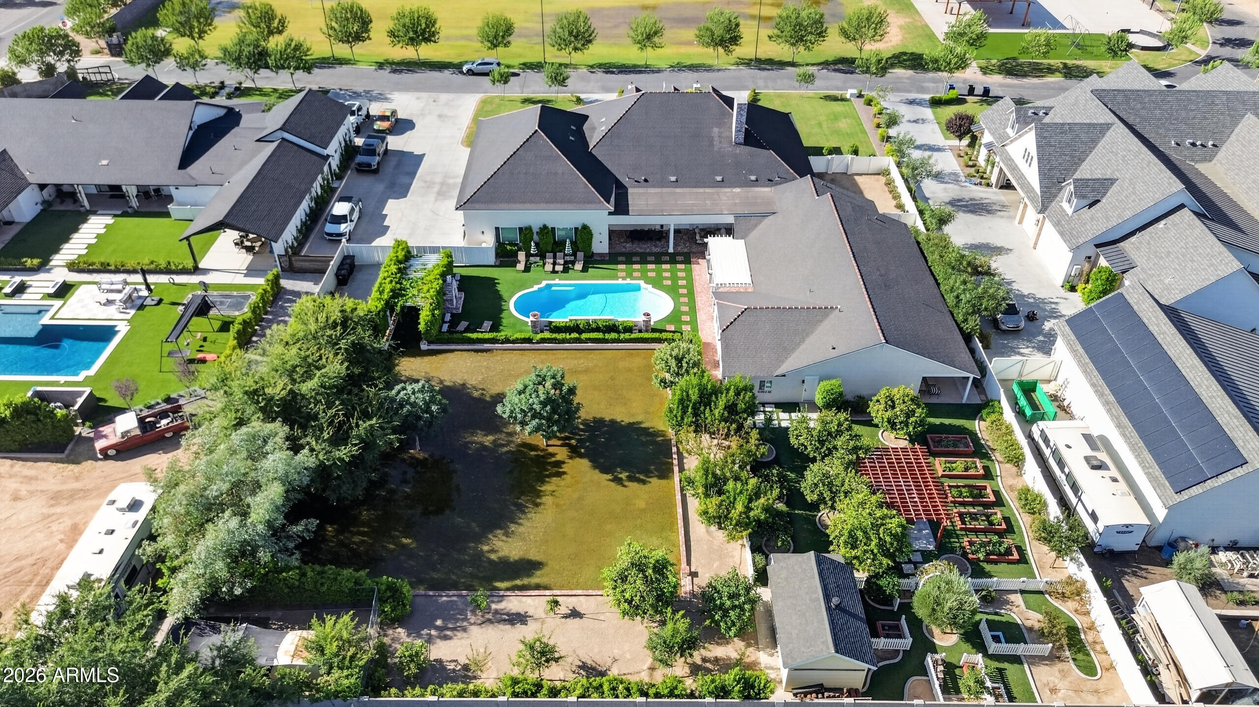 PRICED BELOW APPRAISAL!
Opportunities like this rarely come along.
Welcome to Haven Groves - a true unicorn in Gilbert. An exclusive gated enclave of just seven custom homes centered around a beautiful three-acre community park with lush grass, a playground, firepit and sports court. It's the kind of neighborhood where kids play outside, neighbors gather, and life feels a little slower.

Located in South Gilbert, the home is just minutes from SanTan Village, Discovery Park, multiple hospitals, gyms, shopping, dining, and top-rated schools, offering both convenience and lifestyle in one of the East Valley's most desirable areas.

Set on a full one-acre lot with horse privileges, the home offers 5,623 square feet with 6 bedrooms, 5 full baths, and 2 half baths. A six-car garage includi massive attached fully insulated RV garage, along with a circular drive, provides exceptional space for vehicles, toys, and projects. Inside, natural light fills the home and highlights crown molding, coffered details, and warm, inviting living spaces centered around a beautiful fireplace. The kitchen sits at the heart of the home and features an imported Hallman double gas oven, pot filler, custom hood, quartz countertops, walk in pantry and generous space for cooking and gathering. Bulter's pantry with appliance station and walk through to dining room.

The layout includes a private den for work or creative space, along with guest quarters featuring its own living area and full kitchen, ideal for extended family or long-term guests.

The backyard was designed for gathering, with three sets of French doors opening to a covered patio, outdoor fireplace, sparkling pool, hot tub, and multiple seating areas. A built-in BBQ, smoker, pizza oven, outdoor pool bathroom, and outdoor shower make entertaining effortless.

The grounds are equally special, featuring an orchard with over two dozen varieties of fruit trees including blood orange, lemon, lime, grapefruit, apple, pomegranate, plum, apricot, pear, grapes, and blackberries, along with a rose garden and peaceful meditation garden.

Upgrades include two tankless water heaters, new HVAC systems in 2024, upgraded insulation, and a finished attic storage space with pull-down staircase access from the pantry.

With horse privileges, a storage/playhouse, and room to expand, build, or simply enjoy the space, this property offers the kind of land and lifestyle that's becoming harder and harder to find.

Prom photos on the front porch.
Holiday dinners that stretch late into the evening.
Kids growing up in the park down the street.
And someday, grandkids running through the backyard.

A home built for gathering.
A home designed to grow with you.
A place where the best chapters of life are still ahead.

Homes like this rarely come available in Gilbert. Welcome home.