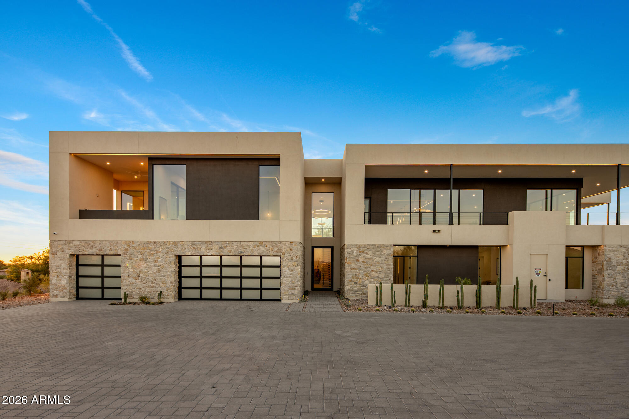 Positioned at the pinnacle of the prestigious PV Biltmore area in Phoenix, this extraordinary contemporary estate offers a rare opportunity to own one of just 14 exclusive custom residences within a private gated enclave. 
Set on a commanding 28,898 square foot hill top homesite, the property captures breathtaking and unobstructed panoramic views in every direction, including the iconic Wrigley Mansion, the dramatic silhouette of Camelback Mountain, the rugged beauty of Piestewa Peak, the Biltmore skyline, and sparkling city lights stretching across the Valley. This brand-new, modern contemporary single-family residence offers just over 6,072 square feet of refined livable space, thoughtfully designed and built by, WeBuild Residential, a contemporary custom home design and build firm. Bryan Schlueter, CEO of WeBuild Residential, shares, "Our vision was to create an amazing masterpiece that felt as if it was effortlessly designed to maximize both luxury and livability. We wanted it to be comfortable and highly livable, while delivering an incredible flair for dramatic architectural design."
The home features five spacious bedrooms, four and a half bathrooms, and a versatile flex room ideal for a private theater, fitness studio, or executive office. A dedicated golf simulation room  or full wine cellar further elevates the entertainment experience, creating a true resort-style environment at home.
Seamless indoor-outdoor living defines the main level, where expansive walls of glass open to wraparound decks and an elevated infinity-edge pool that appears to spill into the Valley below. Whether hosting sunset gatherings or enjoying quiet mornings above the city lights, the setting is simply unparalleled.
Additional highlights include four-car garage with room for expansion, a private elevator connecting the garage level to the main living areas, and cutting-edge modern construction with meticulous architectural detailing throughout.