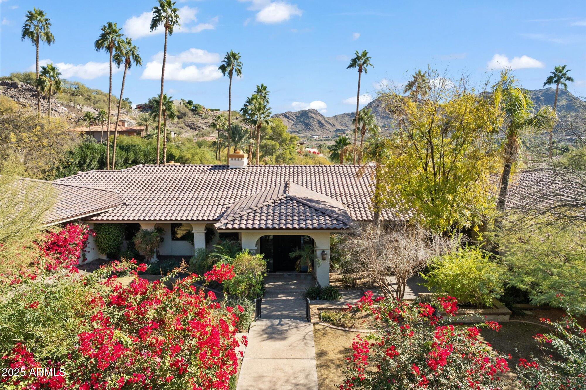 Perched on a premier private lot in the prestigious Tatum Canyon, this exceptional estate, built by Dave Hansen, offers breathtaking panoramic views of Mummy Mountain. Designed for both grand entertaining and comfortable family living, this pristine home boasts timeless elegance and unparalleled craftsmanship. Lush, mature landscaping surrounds expansive covered patios, a built-in BBQ, a private tennis court, and a resort-style diving pool. A beautifully appointed separate guest house enhances the estate's appeal. Inside, polished Italian marble flooring, granite countertops, and top-of-the-line appliances create an atmosphere of refined luxury. The spacious primary suite features a cozy gas fireplace, a spa inspired bath with a multi-head shower, a sunken jetted tub, a private exercise room, and dual walk-in closets. The secondary bedrooms are very spacious with walkin closets and en-suite bathrooms. With an exceptional floor plan and an unbeatable location, this estate is a rare opportunity to experience the finest in Paradise Valley.