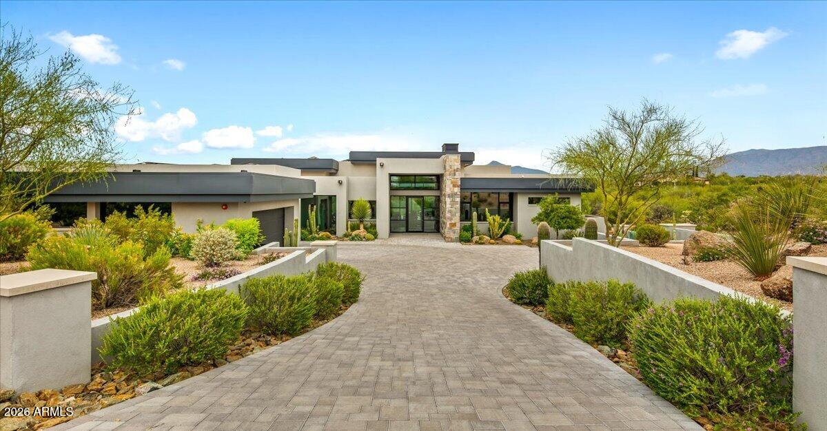 This clean-line contemporary residence is set on a private 1.83-acre lot, capturing stunning northwest views of the Continental Mountains. Highly upgraded and thoughtfully designed, the home features a desirable split floor plan that balances privacy and functionality. The interior showcases a refined, modern aesthetic with concrete-look large-format flooring, subtle industrial metal accents, and an exceptional use of stacked stone that seamlessly transitions from the interior to the exterior spaces.
The spacious chef's kitchen is equipped with premium Miele appliances and complemented by a large walk-through pantry with an additional refrigerator, ideal for both everyday living and entertaining. A dedicated home theater with projector, surround sound, and luxury 
seating creates a true true cinematic experience.
Outdoor living is equally impressive, offering three separate seating patios, an outdoor fireplace, and ceiling-mounted heaters--perfect for year-round enjoyment. Additional features include an oversized 3-car garage and an owned solar power system, significantly enhancing energy efficiency. A Full Golf Membership is available for transfer, subject to club bylaws. Most furnishings may be purchased under a separate bill of sale, presenting a turnkey opportunity in a serene desert setting.