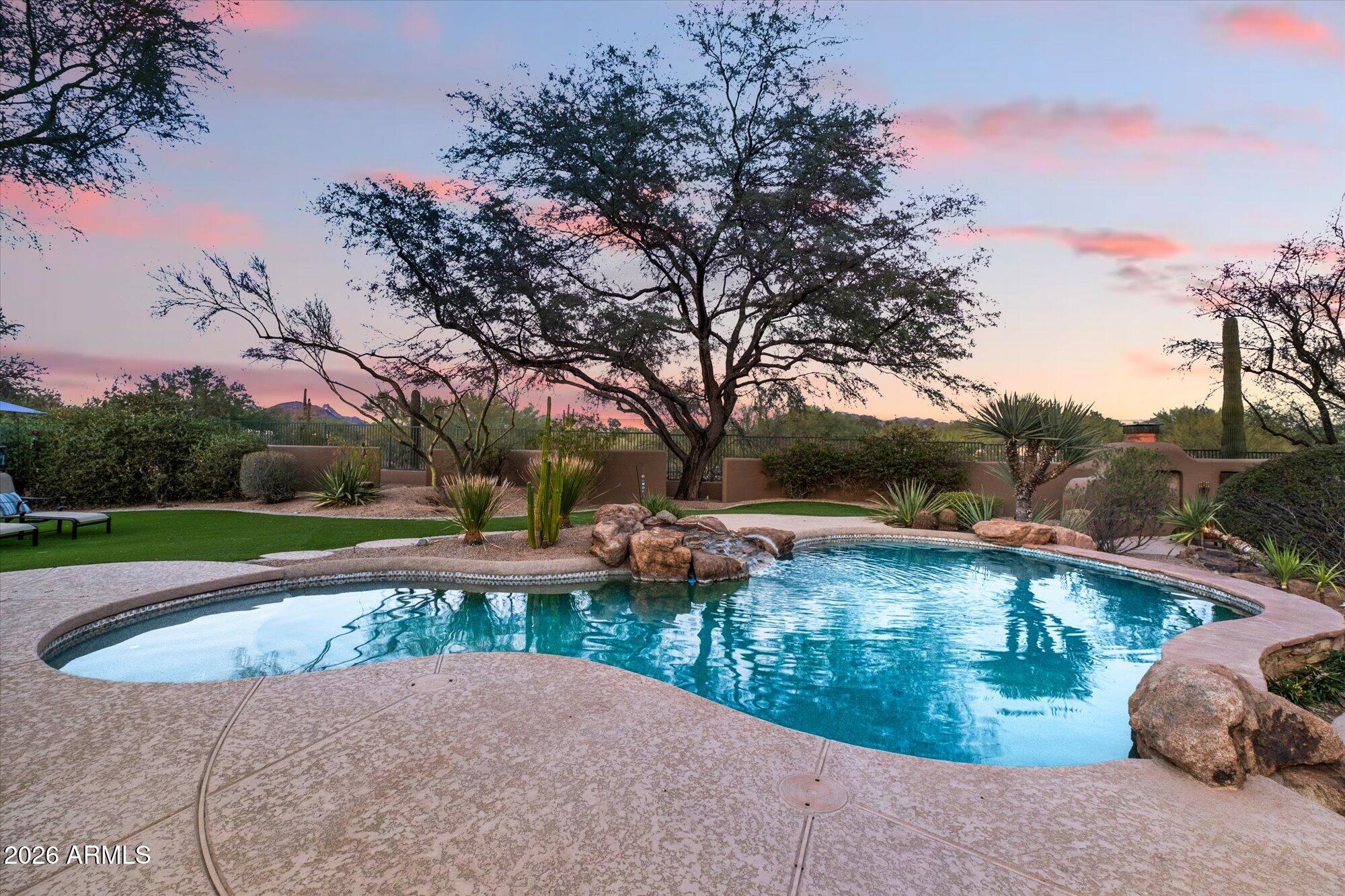 Behind the gates of Arroyo Canyon I in Sonoran Hills, this beautifully maintained estate sits on over an acre at the end of a cul-de-sac, with a beautiful NAOS wash behind you and incredible Pinnacle Peak views. Tucked away yet minutes to top-rated schools, freeways, grocery stores, restaurants, and golf clubs, the location is the best! A private courtyard welcomes you into a split floor plan with 3 bedrooms plus a den, 12-foot ceilings, alder 8' interior doors, walls of glass , and a 3-car garage. Enjoy a private resort-like backyard with custom pool, waterfall, built-in BBQ, wood-burning fireplace, privacy, space, and unforgettable sunrise and magical desert sunset skies.
