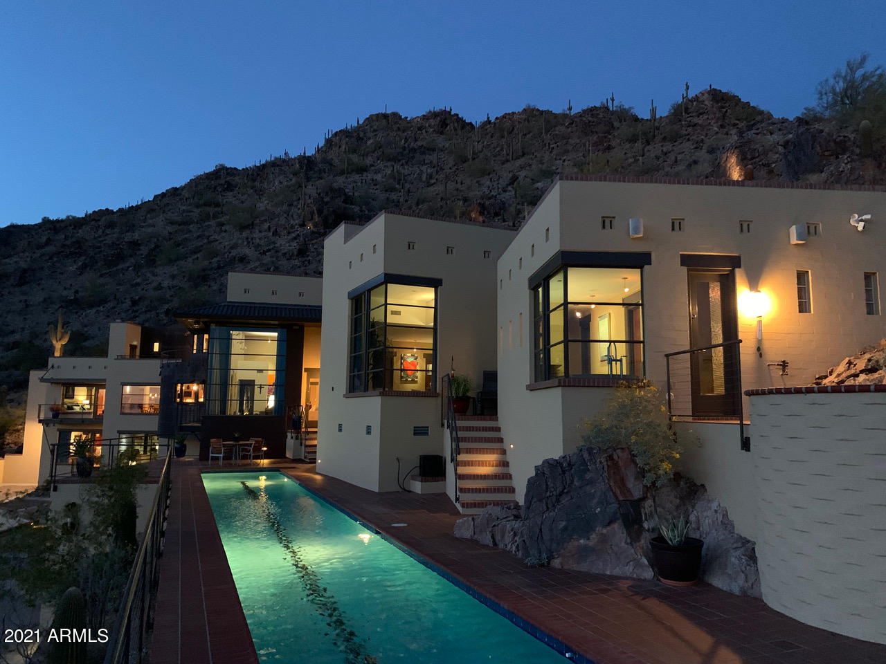 Spectacular views abound from this stunning 6,200 square foot contemporary located high on a saguaro-covered hillside set against the Phoenix Mountains Preserve. Dual gated driveways lead up to the motor court, 4 car garage and grand entry. The main living area features a great room with dramatic views on all sides, highlighted by city lights twinkling beyond the 82' lap and play pool. A spacious master suite leads to a private spa perched high above the Valley. Gourmet kitchen, game room and second en suite bedroom complete the main floor, with a beautiful backyard entertaining area flowing seamlessly into the mountain above. Reminiscent of timeless Hollywood Hills architecture and surrounded by Paradise Valley and The Biltmore area, this home is a contemporary classic. Spectacular views abound from this stunning 6,200 square foot contemporary located high on a beautiful saguaro-covered hillside set against the Phoenix Mountains Preserve. Designed and meticulously built into the mountainside to maximize the breathtaking views, dual gated driveways lead up to the motor court, 4 car garage and grand entry. The main living area features a great room with dramatic views on all sides, highlighted by city lights twinkling over the 82' lap and play pool built into the hillside. A spacious master suite leads to a private spa perched high above the Valley. Gourmet kitchen, game room and second en suite bedroom complete the main floor, with a beautiful backyard entertaining area flowing seamlessly into the mountain above. 

A large attached guest house with separate entrance, living room and full kitchen is located on the ground floor. An elevator connects to the main level and the third floor en suite bedroom with panoramic views and large balcony overlooking the Valley. Reminiscent of timeless Hollywood Hills architecture and surrounded by Paradise Valley and The Biltmore area, this home is a contemporary classic.

The eco-friendly design has none of the large mountainside scars so typical of hillside construction, giving the impression the home was gently placed into the mountain. Featuring solid reinforced masonry, steel and copper construction, top-of-the-line materials are utilized throughout, including custom African Striped Mahogany doors/trim, bamboo floors, handmade custom ceramic tiles, the finest quality appliances and much more. This indulgent home features 6 masonry fireplaces (4 inside and 2 outside) and multiple spacious balconies and decks, providing many inviting choices when it comes to the location of your daily sanctuary. When you add in the possibility of working from home by utilizing one of the non-master bedrooms or by easily converting the guest house living room, this home becomes the ultimate in hillside cocooning.