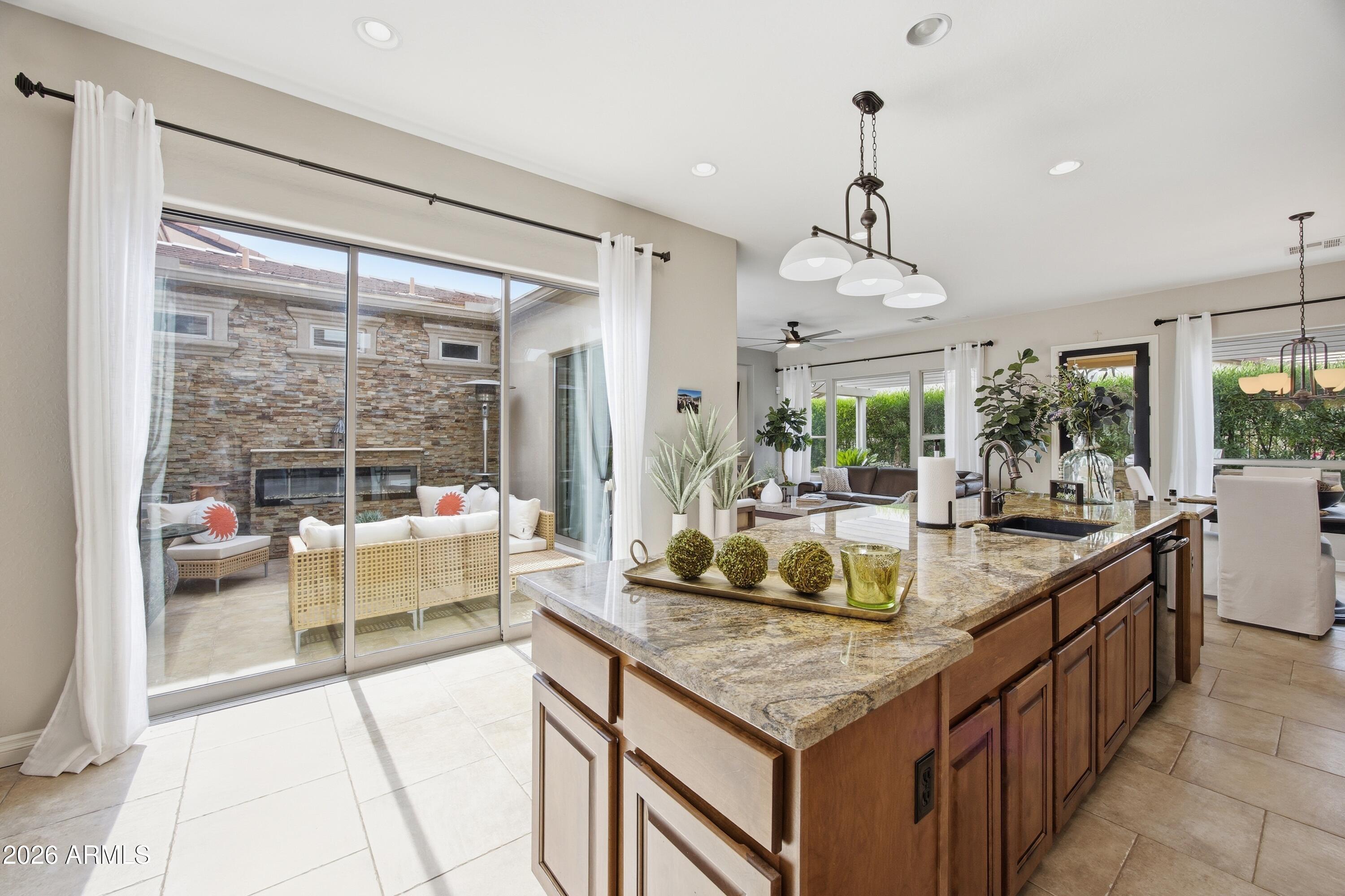 Corner lot home in Encanterra with one standout feature you won't find anywhere else -- a private atrium right in the middle of the house that brings in natural light and makes every room feel connected. Inside, the open kitchen has an oversized island with room for the whole family, granite counters, and a big sliding glass door that opens straight to the atrium patio. The primary bath has a step-up soaking tub, separate walk-in shower, and high ceilings. The third room works as a bedroom, office, or flex space -- whatever you need. Out back, a covered pergola, built-in BBQ, and mature hedges give you real privacy. Well-maintained, move-in ready, and one of the more unique floor plans in the community.