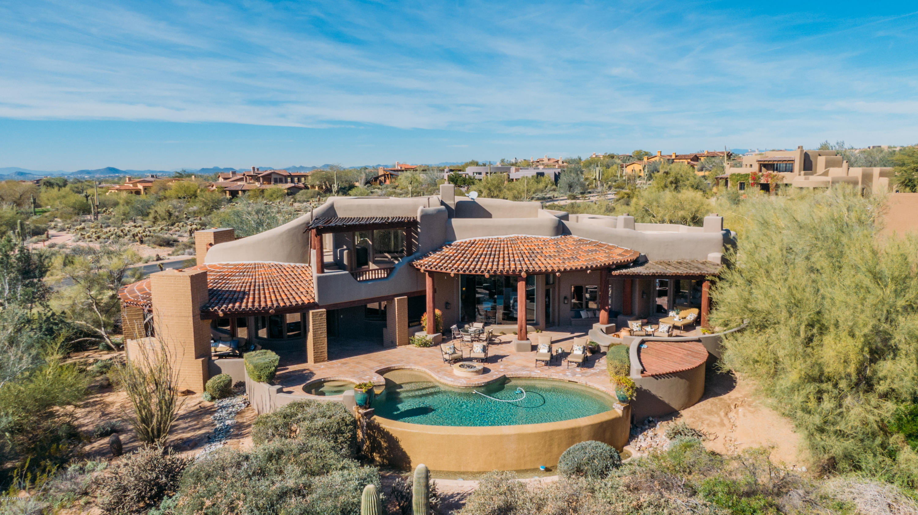 Backing to the 15th green and 16th tee box of the Country Club at DC Ranch golf course, this home is perfectly designed to take in breathtaking mountain, golf course and city views. Tucked away in a quiet cul-de-sac at the end of an extended paver stone driveway, this private retreat lives like a single level home with all rooms except one guest suite on the main floor. The master split floorplan includes 3 bedrooms, an office, 2 powder rooms and wine room on the main floor, and features gorgeous stone flooring, wood floors, beamed ceilings and 3 distinctive fireplaces. The upstairs guest suite offers 2 balconies, and leads to a roof deck offering panoramic city views. Outdoor living is easy with a generous covered sitting area with fireplace, 2 fire pits, and a negative edge pool and spa.