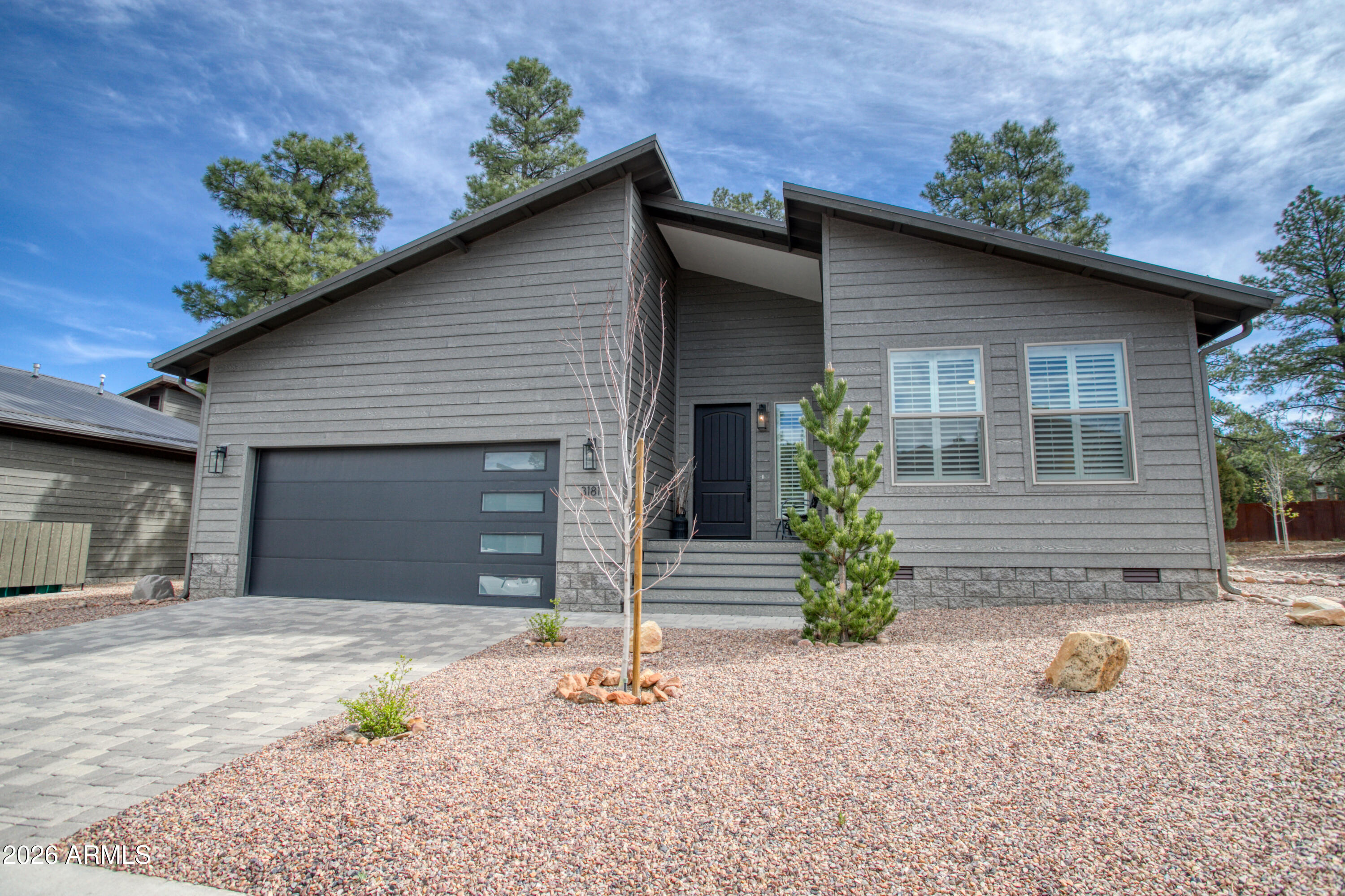 Located in the cool white Mountains of Arizona is this impressive 1,799 square-foot 3-bed, 2-bath home in one of the most desirable gated communities, Creekside at Eagle Mountain Estates. This site-built home sits on a beautiful lot surrounded by tall pines in the neighborhood. Opening the front door and going through the foyer, you will feel instantly at home as you enter the spacious, dynamic Great Room with vaulted ceilings, a stone-surrounded fireplace w/beautiful wood mantel, and the beautiful chef's kitchen to the right. Main living area features include new custom-made plantation shutters throughout the home's interior, two sliding Barn Doors, and direct access to a beautiful, semi-private, covered back deck with a new hot tub, all accessible from the living area. The open-concept Chef's kitchen features Quartz countertops, top-of-the-line appliances, upgraded self-closing cabinet doors and drawers, and a walk-in pantry. The split-level primary suite is the perfect size, with a well-designed bathroom, while the other 2 rooms (bed + bed/den) are separated. A small office area off the kitchen, a full-size pantry, and a full-size laundry room w/extra storage room off to the left. The front and backyard have been professionally landscaped and are protected from weeds by weed barriers encased beneath the rocks, making the landscaping virtually maintenance-free. Additional highlights include a 2-car garage, a metal roof w/ rain gutters, Hardie Board siding, and a concrete paver driveway.