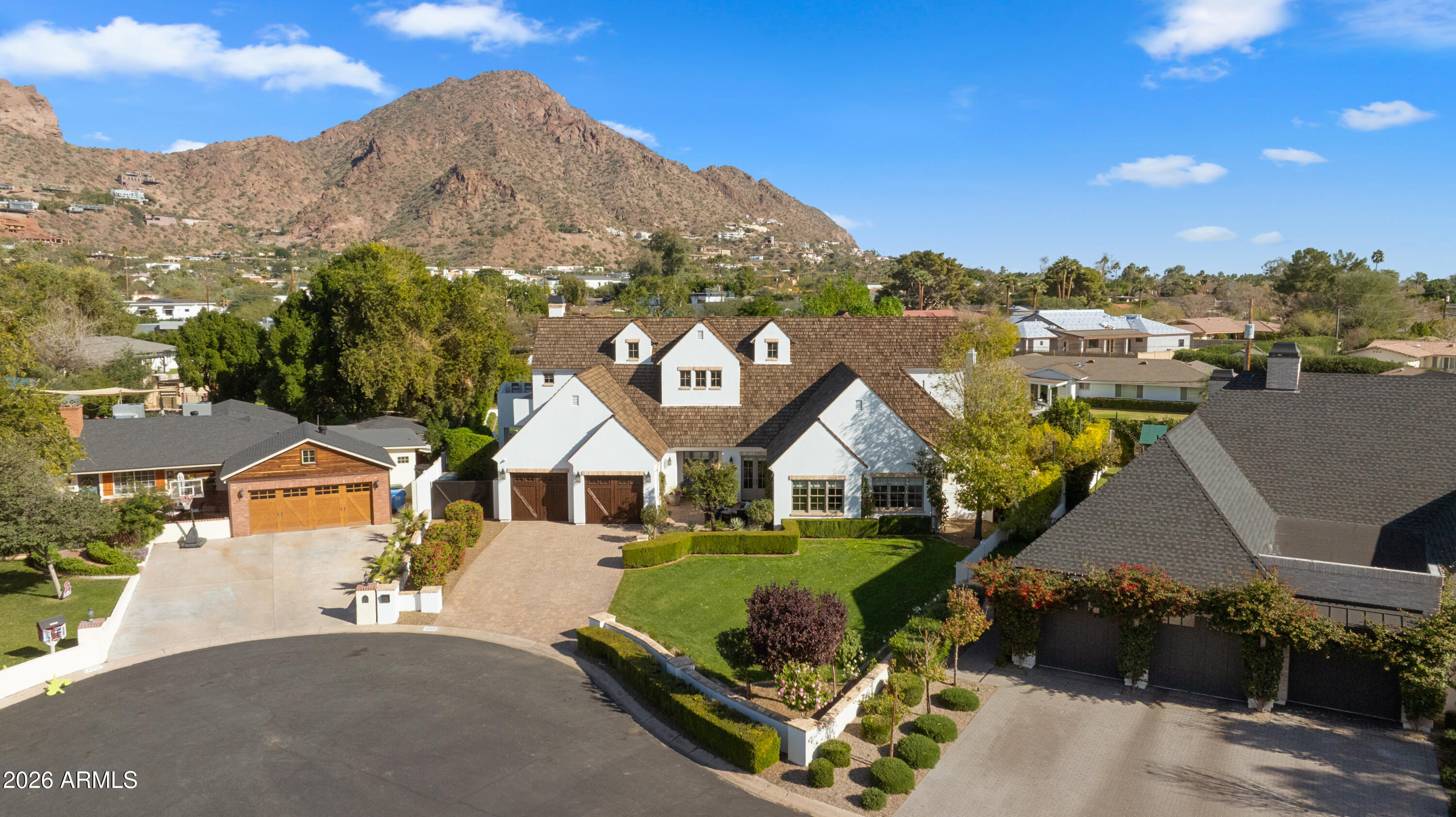 Arcadia rarely offers this combination of location, condition, and great value! Tucked on a private cul-de-sac just off Exeter Blvd with iconic Camelback Mountain views, this beautifully maintained home has been priced to create an immediate opportunity for a discerning buyer. It is not a distressed sale, but a motivated seller who has made a deliberate decision to move the home quickly.  Inside, the craftsmanship speaks for itself: wainscoting, crown moldings, French oak floors, and wood-cased windows set the tone. The great room opens seamlessly to the backyard, a resort-style retreat with a pool, built-in grill, firepit, and multiple patios made for year-round Arizona living. The main level hosts a luxurious primary suite and two additional bedrooms. Upstairs, two private suites, a wet bar, and a bonus room offer flexibility for work or play.  Located within minutes to The Henry restaurant, AJ Foods, Scottsdale Fashion Square, Phoenix Sky Harbor. The seller just made this gorgeous home the most compelling opportunity in the neighborhood!