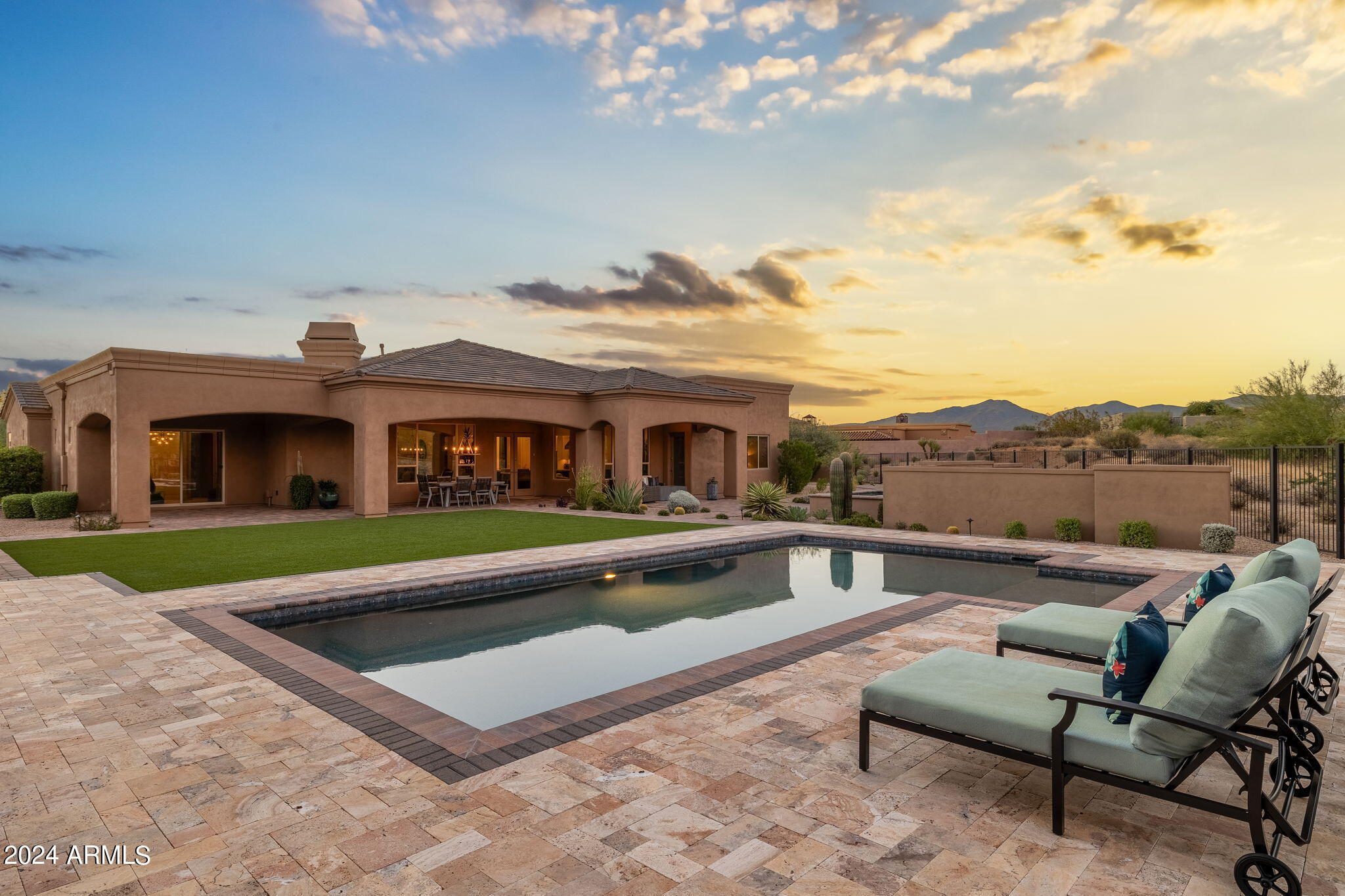 Welcome to this exquisitely stunning updated custom home on a private one-acre cul-de-sac lot with unobstructed mountain views in the gated bedroom community of Sierra Boulders North. The main house boasts three spacious ensuite bedrooms and an additional fourth bedroom equipped with custom built-in cabinetry and a walk-in closet that can double as an office. European white oak floors grace the main living areas and are accentuated by custom woodwork and ceiling beams in the great room. Culinary enthusiasts will delight in the large island adorned with leathered Taj Mahal quartzite countertops, Wolf, Sub Zero, and Cove appliances, and a dry bar with wine and beverage coolers. Love entertaining? Guests and/or multi-generational living is possible with the extraordinary 1,171 sq ft detached guest house, newly constructed in 2019 with elevated finishes that are sure to impress the most discerning buyer. The simple-to-use Control4 Smart Home System operates the exterior lights, home security system, indoor and outdoor cameras, audiovisual systems, and thermostats throughout both homes. Multiple outdoor living spaces can be enjoyed year-round, complete with a stunning rooftop deck, large covered verandas, outdoor gourmet kitchen with a Mugnaini wood-fired pizza oven imported from Italy, Fire Magic BBQ grill, warming drawer, beverage cooler, sink with disposal, and misters that keep you cool all summer long. Cozy up by the outdoor fireplace while roasting marshmallows and telling stories. The outdoor oasis includes a generous heated salt water Pebble Tech pool with upgraded pop-up cleaning system and spa with a mesmerizing water feature that comfortably seats nine. The lush yard is adorned with vibrant green turf, ideal for children's play, yoga sessions, or soaking up the sunshine while playing catch with your furry four-legged friends. No expense was spared in creating this masterpiece with $250,000 recently invested in updates. Outside, fresh herbs and vegetables are easily accessible from three beautifully constructed irrigated raised garden beds. For car enthusiasts or those with a passion for hobbies, the oversized 4-car garage with epoxy floor, built in cabinetry, EV charging station, and organization system offers ample space for vehicles and toys alike. This property is a true gem in today's market. Make it your dream home today!