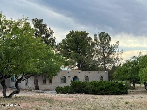 PRICE REDUCTION! Majestic mountain views from the comfort of this Sante Fe style 4 bedroom/2 bathroom 2,298 square foot home! Located on a corner lot on 1.48 acres with large mature trees. This is the peaceful desert oasis you need! Whip up your favorite meal in the roomy kitchen with cabinet & counter space galore. Includes an appliance garage, lazy susan, glass cooktop, wall oven, roll-out shelves and desk.  Need more room?? Check out the ADDITIONAL detached 2 car garage! Or the craft/sewing room with built-in cubbies for storage. During the winter, enjoy a cozy fire in front of the Beehive fireplace in the family room. After a storm, check out the waterfall in the Huachuca Mountains. There is plenty of room to stretch out in this large home. Call for a private tour today.