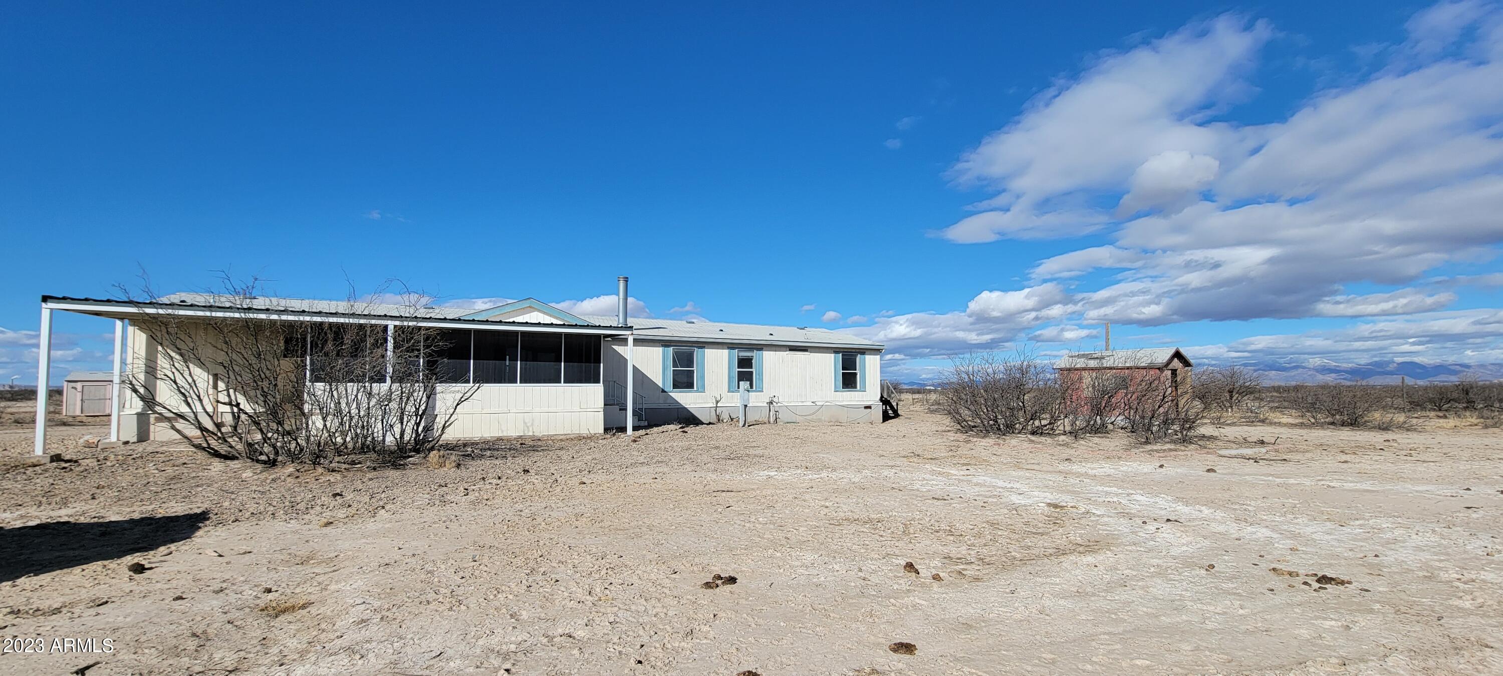 Here is a great opportunity to purchase a large home with a barn and private well on just under 40 acres at a great price. The home features a split plan with a large kitchen and family room. The secondary bedrooms are good sized and the laundry is located by the secondary bedrooms. There is a large living room with a real fireplace for the cold winter nights. The master suite is HUGE and boasts his and hers baths with a large walk thru closet in between. You will enjoy the screened patio on the front to watch the amazing Arizona sunsets. The property is fenced and cross fenced as well. This is an AS IS sale.