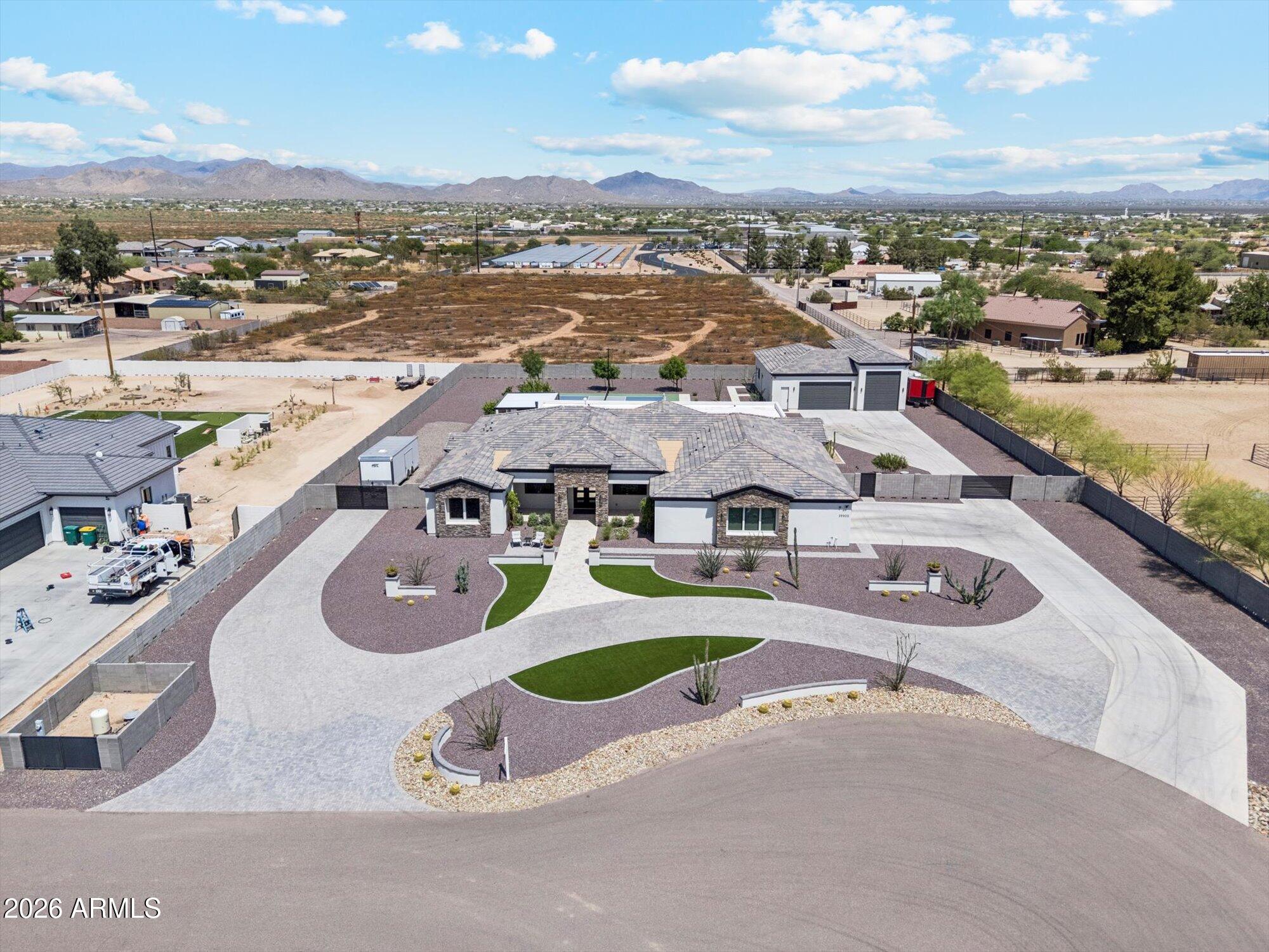 Welcome to the pinnacle of Desert Hills luxury! A rare 2022 custom masterpiece in coveted North Mountain Estates, tucked at the end of a cul-de-sac on 1.327 acres of paved, subdivision-style living. Inside, soaring open-concept spaces, a spa-worthy master suite, and high-end finishes impress at every turn. The chef's kitchen is next-level: 60' Wolf range, double island, a ton of cabinet space, and dual 100-gal propane tanks. Outside, host in style with a brand-new pickleball court and covered ramada. Car collectors, this is your dream; 5-car attached garage + 50-amp, PLUS a jaw-dropping 2,200 SF conditioned detached RV garage with 190 SF workshop, lift, bathroom, and RV septic/water/50-amp hookup. This is a lifestyle property that Desert Hills has been waiting for!!!
