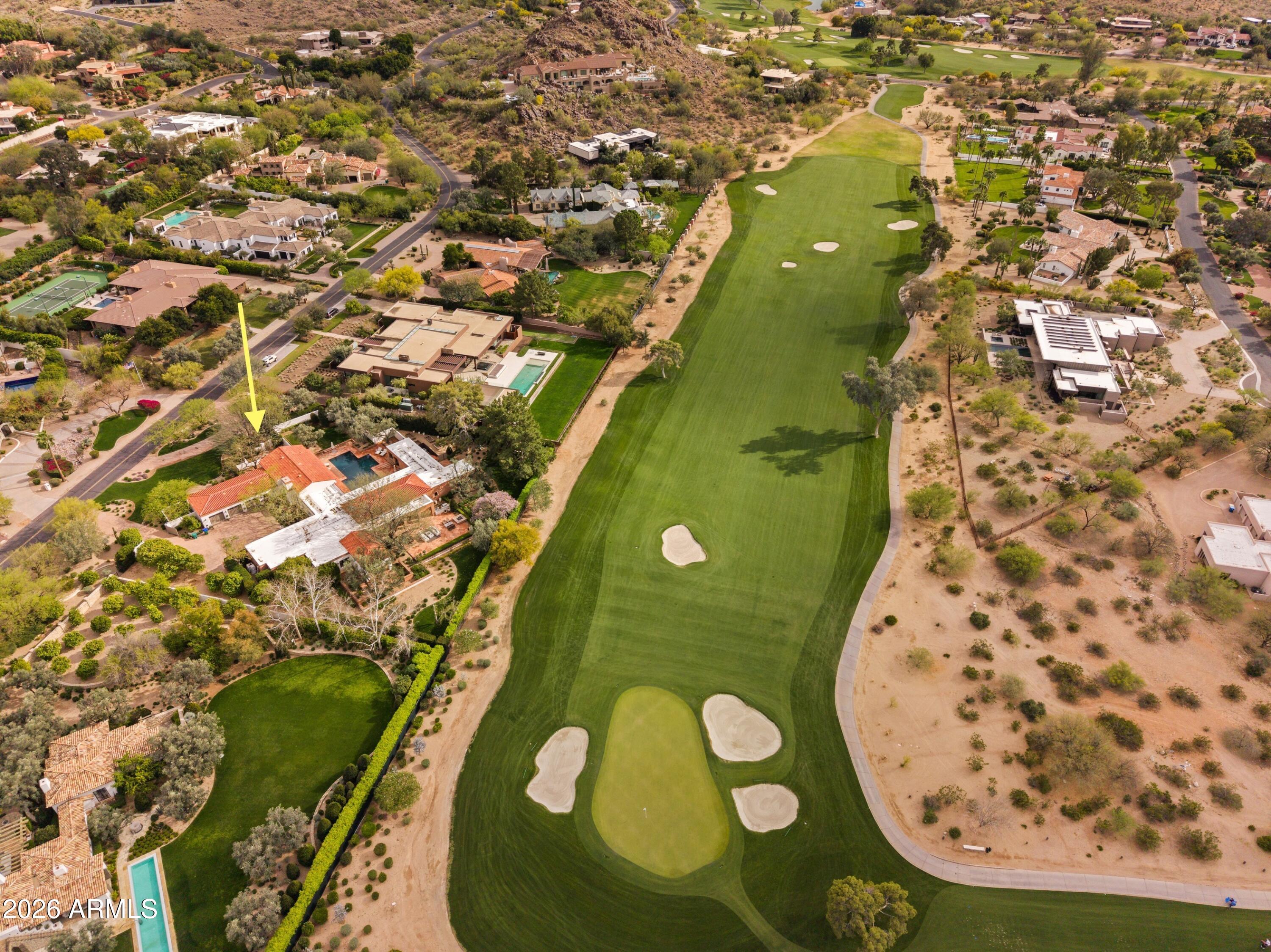 A rare offering on the 4th fairway of Paradise Valley Country Club, this 6604 sf desert/modern - extensively remodeled (GM Hunt 2013) estate blends timeless character with a refined modern edge. Highlighting a private courtyard pool, the home features Saltillo and wood floors, floating beam ceilings, and restored antique doors. Framed by views of Mummy Mountain in the front and the Phx Mountain Preserve beyond, the home sits along the golf course, offering a picturesque setting. The backyard is designed for both entertaining and everyday living, w/multiple patio spaces, expansive lawn, mature trees, and a curated vegetable garden. The primary suite features vaulted ceilings, a spacious bathroom, 2 water closets and large dressing room. The reimagined kitchen showcases mid-century modern... influence with Viking appliances, double ovens, a prep kitchen, and ample storage. Multiple living areas open seamlessly to lush grounds with olive and citrus trees, grass, and a brick patio w/ firepit. Three additional bedrooms, an office/library, 4 car garages + flexible spaces offer versatility. A warm, architecturally rich property in one of Paradise Valley's most coveted locations.