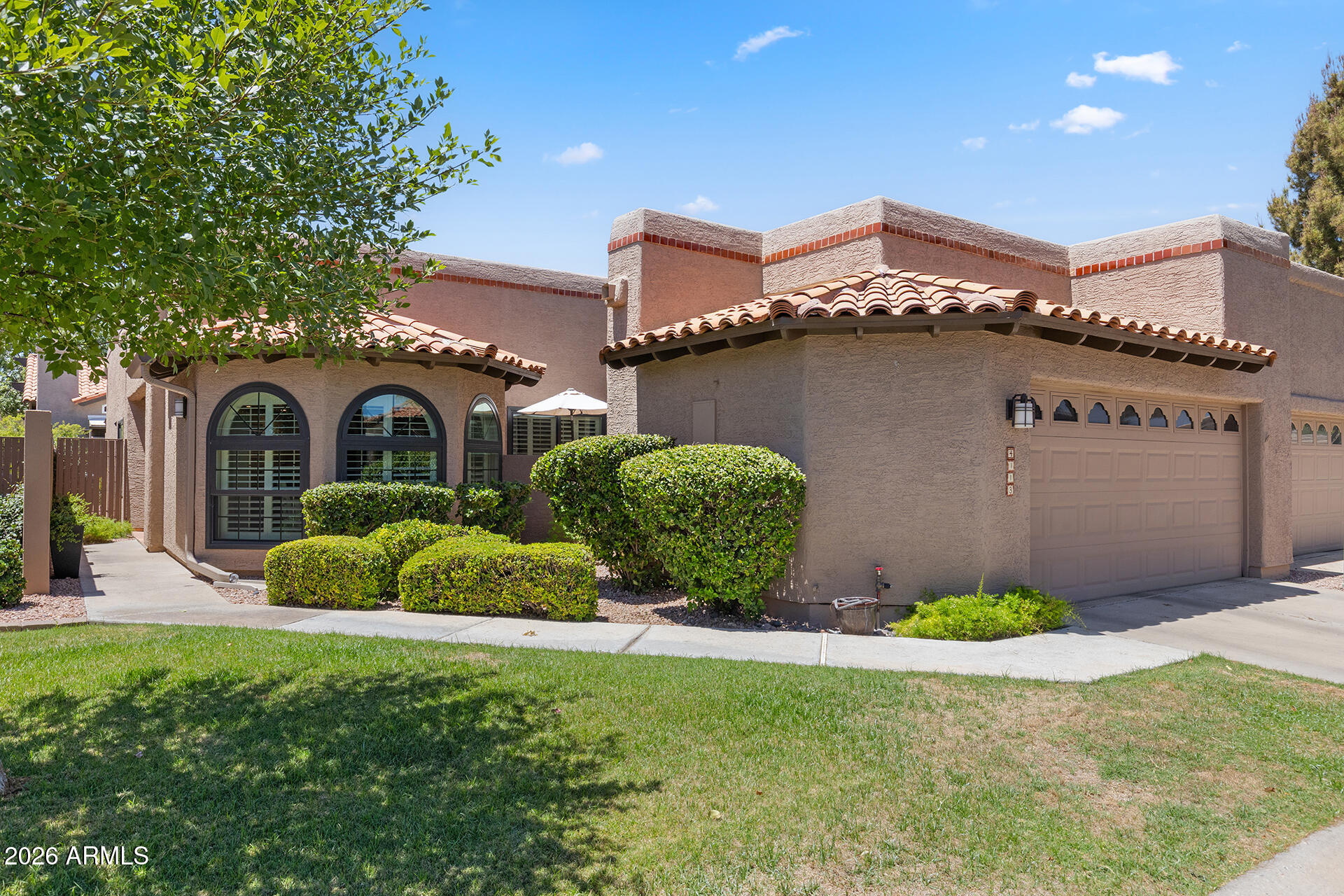 UPDATED GATED TOWN HOME IN A PRIME CENTRAL PHOENIX LOCATION! Filled with natural light & soaring ceilings, this beautifully updated home offers a spacious living room anchored by a statement brick fireplace & oversized windows with new plantation shutters throughout. The kitchen features updated granite countertops, rich-toned cabinetry with pull-out shelving, stainless GE Profile appliances including dual wall ovens, recessed lighting, breakfast bar seating & a generous dining area surrounded by windows. The primary suite offers new wood-look flooring, backyard access & an ensuite with dual vanities, updated countertops & a remodeled walk-in shower. A separate den/office provides flexible living space & could serve as a potential third bedroom. Additional highlights include a 2022 water heater & an epoxy-finished garage featuring built-in cabinetry, a work bench & a 220V outlet ready for potential EV charger installation. The private backyard creates a true extension of the home, offering an oversized covered patio with updated travertine, lush mature landscaping, synthetic grass, multiple conversation areas & a peaceful, low-maintenance setting perfect for both everyday enjoyment & entertaining. The gated community features a heated pool, spa, tennis & pickleball courts & next to Stone Creek golf course. Easy access to SR-51, Paradise Valley shopping, dining, recreation & nearby hiking & biking trails.