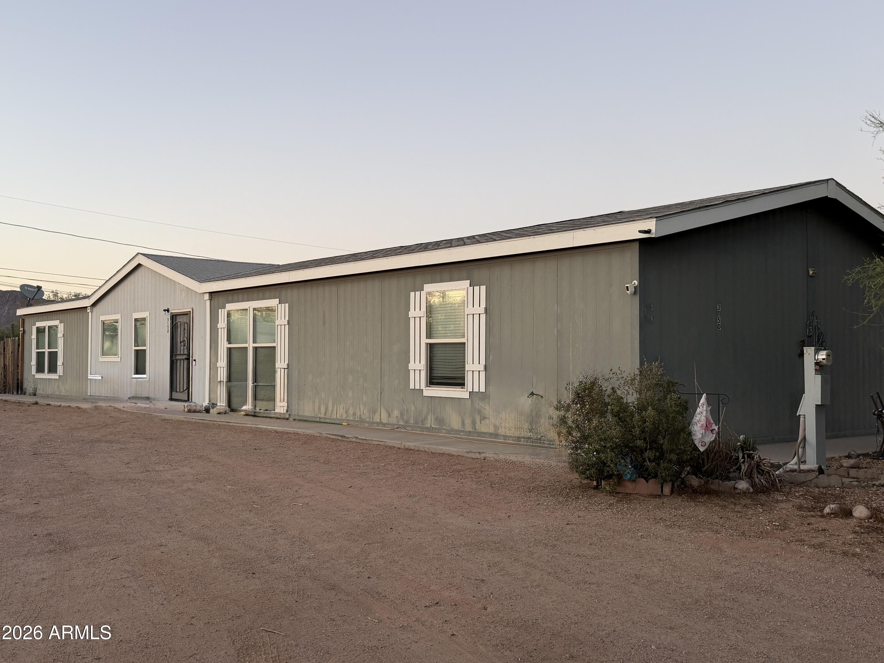 NO HOA! I REPEAT, NO HOA! Built in 2018-by Clayton Home sits on 0.41-acre lot, offering the perfect blend of modern comfort and wide-open freedom. Step out onto your east-facing covered patio to enjoy your morning coffee against the breathtaking backdrop of the Superstition Mountains. Inside, you'll find a spacious 2,129 square-foot floor plan featuring 4 generous bedrooms, 2 full bathrooms, and separate living and family rooms--perfect for entertaining or family movie nights. The heart of the home is the kitchen, complete with an island, breakfast bar seating, and a walk-in pantry. The split-floor-plan places the primary suite on its own side of the home for ultimate privacy. 3 Sheds for storage. Huge Driveway with room to build a garage.