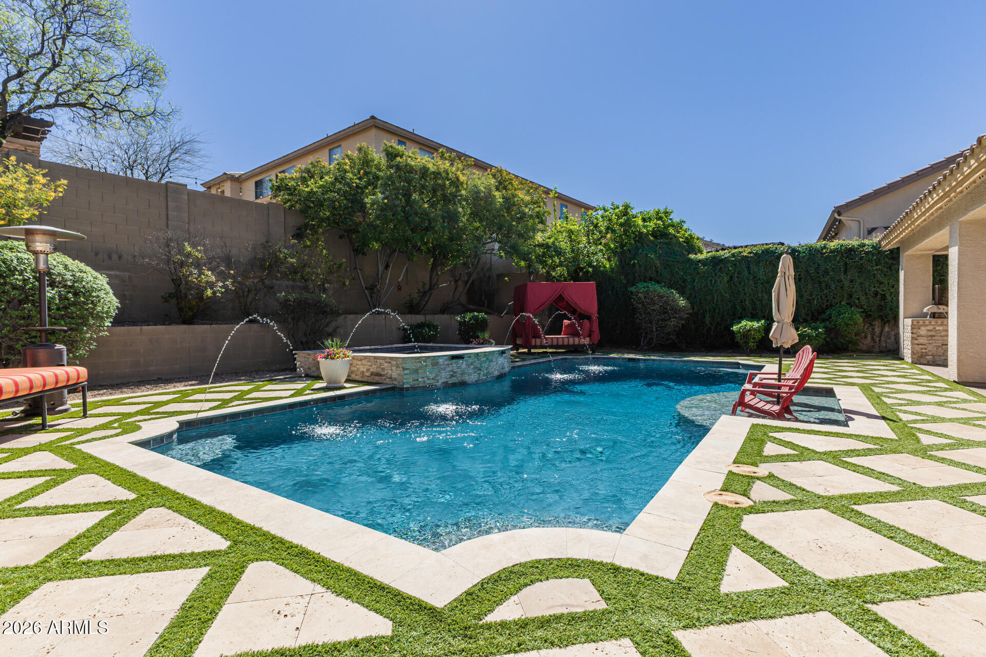 Ultimate Anthem privacy meets resort-style luxury at 38809 N Courage Court. Welcome to this spectacular 5,148 sq. ft. Spirit model, perfectly situated on a rare 1/3 acre cul-de-sac lot with only one neighboring home and a beautiful wash backdrop for exceptional privacy, scenic desert views, and a peaceful Arizona setting. From the moment you arrive, the home makes a memorable impression with custom double iron front doors, a gated pavered courtyard, and an inviting outdoor gas fireplace.
Inside, the thoughtfully designed floor plan is ideal for everyday living and upscale entertaining, featuring brand-new wood luxury vinyl plank flooring throughout, 5 spacious bedrooms, 4.5 baths, a private den, and a desirable main-level guest suite ideal for multigenerational living, visiting guests, a private workout room, or nanny/in-law quarters. The remodeled modern kitchen is the heart of the home, showcasing a high-end marble backsplash, updated hardware, granite countertops, stainless steel appliances, and a massive center island that opens seamlessly to the family room with its own cozy gas fireplace.
Upstairs, two staircases lead to a spacious second level featuring 4 bedrooms and an expansive bonus room, perfect for a playroom, lounge, game room, or flex space. A dramatic spiral staircase leads exclusively to a permitted 237 sq. ft. addition, bringing the total square footage to 5,148 sq. ft. Designed as a private custom home theater, this impressive space is complete with premium reclining seating, a high-end projector system, and immersive Dolby Atmos surround sound.
The remodeled primary suite offers a peaceful retreat with a spa-inspired bathroom featuring an oversized walk-in rain shower, deep soaking tub, dual vanities, and a large walk-in closet. Step outside to an ultra-private backyard oasis framed by mature trees and lush landscaping. Designed for year-round Arizona living, the resort-style yard features high-end Italian travertine, a heated pebble sheen pool, a 12-person spa, synthetic turf, a custom outdoor gas fireplace, a spacious covered patio, and a built-in outdoor island with a premium KitchenAid BBQ grill.
With unmatched privacy, flexible living spaces, luxury upgrades, a private theater, resort-style backyard, and access to Anthem's parks, trails, pickleball courts, recreation, shopping, dining, and community amenities, this private Anthem oasis truly has it all.