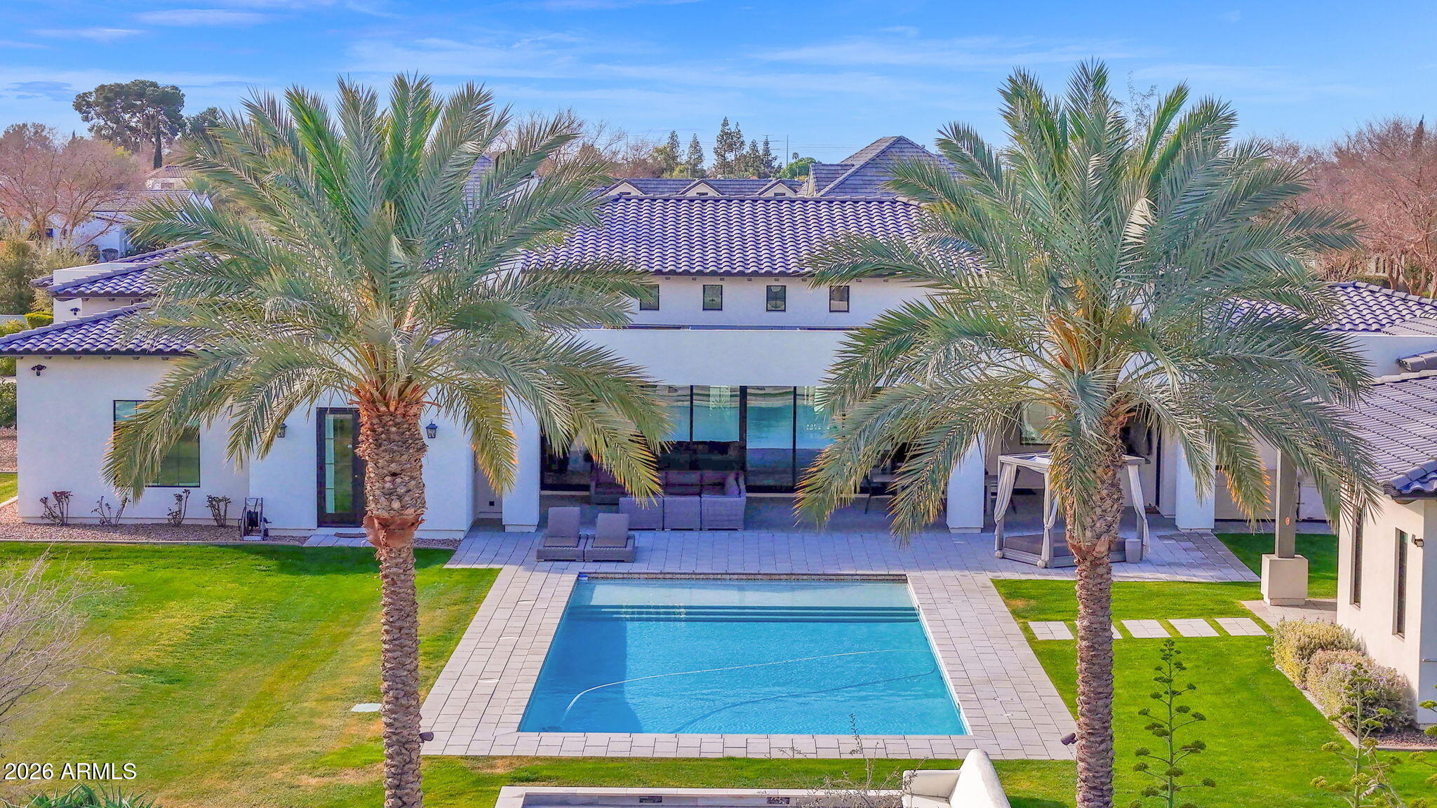 Welcome to an extraordinary custom estate in Mesa. Set on over one acre cul-de-sac lot in the coveted Legacy enclave. Designed for luxury living, grand entertaining, and high-performance fun, this one of a kind property delivers an unmatched lifestyle experience. Step inside to the family room with soaring 14 foot ceilings accented with dramatic all wood beams and an inviting gas fireplace. Massive 30 foot sliding glass doors seamlessly connect indoor and outdoor living. The wide open family room flows into a spectacular double island eat-in kitchen with breakfast bar, quartz countertops,  double sinks & double dishwashers, reverse osmosis system, 6 burner Wolf cooktop with grill, Wolf double ovens, Sub-Zero refrigerator, beverage fridge with wine cooler, ice machine, butler's pantry, hidden 9' x 5' walk in pantry, dedicated coffee bar. This kitchen was built for serious culinary performance and seamless entertaining. The thoughtfully designed split floor plan offers privacy and comfort for all. Primary Suite Retreat has: Gas fireplace, private patio access, 11 foot ceilings, dual closets with stackable washer/dryer, space to add a private steam room, spa like bath with walk in shower, soaking tub, and urinal. There are an additional three en suite bedrooms. All with walk in closets. All three with walk in showers and one with an additional soaking tub. Additional interior highlights include: Private office. Dedicated theater room with Savant stereo system and berber carpet. Oversized laundry room with island, hanging space, and attached 9' x 9' storage room. Powder room bathroom for guests. The home features: White oak engineered hardwood flooring. 8 inch baseboards. Custom tongue and groove cabinetry with soft close throughout. Abundant storage at every turn. Detached Casita is perfect for guests or multi generational living, the private casita includes: Bedroom, bathroom with walk in shower, living space, wet bar with fridge and microwave. The resort style backyard is an entertainer's dream: Sparkling heated 50' x 20' pool with expansive child's play shelf. Theatre style seated fire pit. Huge covered patio with built in misting system. Outdoor Coyote gas BBQ. Dual outdoor TVs. Four zone built in surround sound with directional exterior speakers. Whether hosting gatherings or enjoying a quiet evening under the Arizona sky, this space was designed to impress. The expertly landscaped grounds blend artificial turf and natural grass, highlighted by mature citrus trees including orange, lemon, and tangelo. A large grassy play area provides even more room to enjoy the outdoors. Car enthusiasts and hobbyists will be in awe of the 7 car garage, including one bay with pull through access to the backyard. Outfitted with built in storage, a dedicated workspace. It's as functional as it is impressive. Elegant driveway pavers set the tone upon arrival, while double RV gates open to reveal a truly unique feature. A private go kart race track that encircles the entire property, complete with straightaways, sweeping 90-degree turns, and thrilling hairpin curves. This Legacy masterpiece combines craftsmanship, innovation, recreation, and resort level amenities. All on a rare, expansive lot in Mesa. A truly exceptional property designed for those who expect more. Main house is 5448 sq ft. Casita is 700 sq ft. Total sq ft 6148.