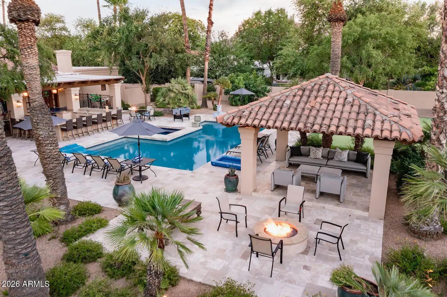 An exceptional Paradise Valley investment opportunity and the only property east of Doubletree Ranch Road currently offered under $4 million. Whether you're looking to acquire a high-performing short-term rental currently generating approximately $300,000 annually.  Renovate to create substantial instant equity or build your custom dream estate the possibilities are endless.This stunning Spanish-inspired residence was completely remodeled in 2005 by Wiseman & Gale and offers timeless architecture with warm, inviting living spaces. The thoughtfully designed floor plan features four bedrooms, a beautiful custom kitchen that opens to the spacious family room, and seamless flow into the dining room, living room, and intimate music room. Step outside to an expansive covered patio designed for year-round Arizona entertaining, overlooking the sparkling pool, putting green, and sport court. Situated in one of Paradise Valley's most desirable neighborhoods, this is a rare opportunity to own a property with exceptional upside, lifestyle, and long-term value.