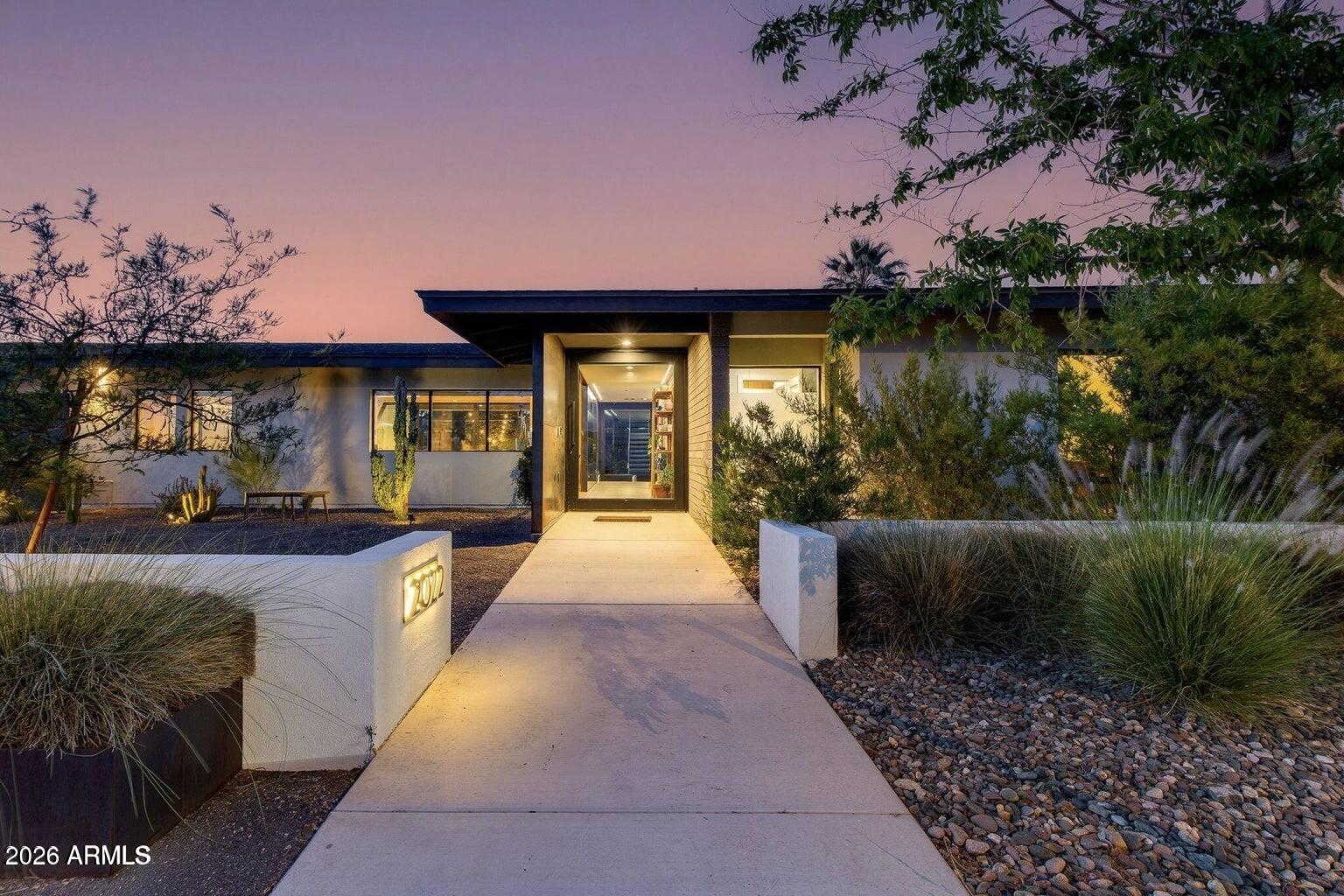 Fully reimagined in 2021, this architecturally striking 5 bed, 3.5 bath residence blends modern design with warm, organic finishes. Flooded with natural light, the open-concept layout is anchored by soaring cathedral ceilings, dramatic steel elements, and exposed block details that create a bold yet inviting aesthetic.
At the heart of the home, the kitchen makes a statement with custom wood cabinetry, sleek black granite countertops, an oversized island, and premium stainless steel appliances. 
Expansive sliding glass doors dissolve the boundary between indoors and out, opening to a private backyard complete with a salt water pool, curated desert landscaping, and multiple areas to unwind or entertain. 
Two spacious primary suites include patio access, walk-in showers with freestanding tubs and walk-in closets. A rooftop deck captures sweeping mountain and city views, delivering a rare vantage point and the perfect setting for sunset gatherings. A three car garage offers ample space for storage. 
This is modern desert living at its finest.