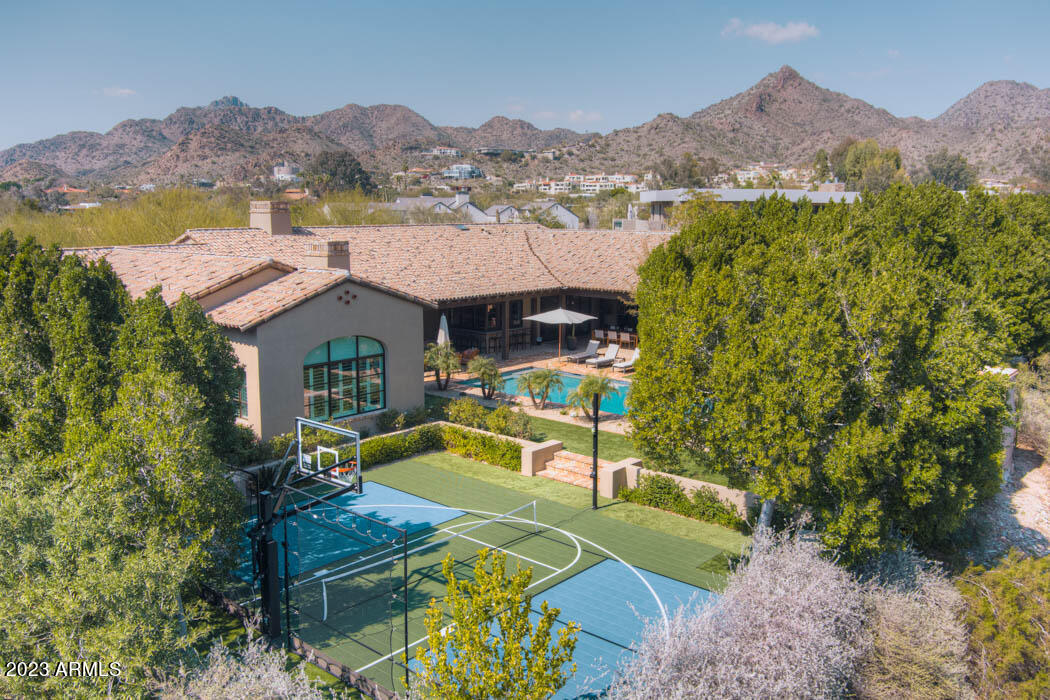 In the heart of Paradise Valley lies a stunning resort style Santa Barbara modern nestled between Biltmore and Phoenician right by PCDS. Inviting indoor outdoor vibe with surround sound and eat in kitchen bar makes it feel like a vacation year round. Master and office or second en-suite with front patio access on one side, kids living/ homework station and three en-suite bedrooms on second wing of home. Large open great room concept with second living room, wine entertaining room, large mudroom drop zone and separate detached casita with its own kitchenette and bath. Low care lush yard and new pickle or sport court, heated pool & multiple entertaining fire places. A quick beach bike to Chelsea's Kitchen, Lon's and all of Arcaida's best shops and dining. Newer build impeccably maintained.