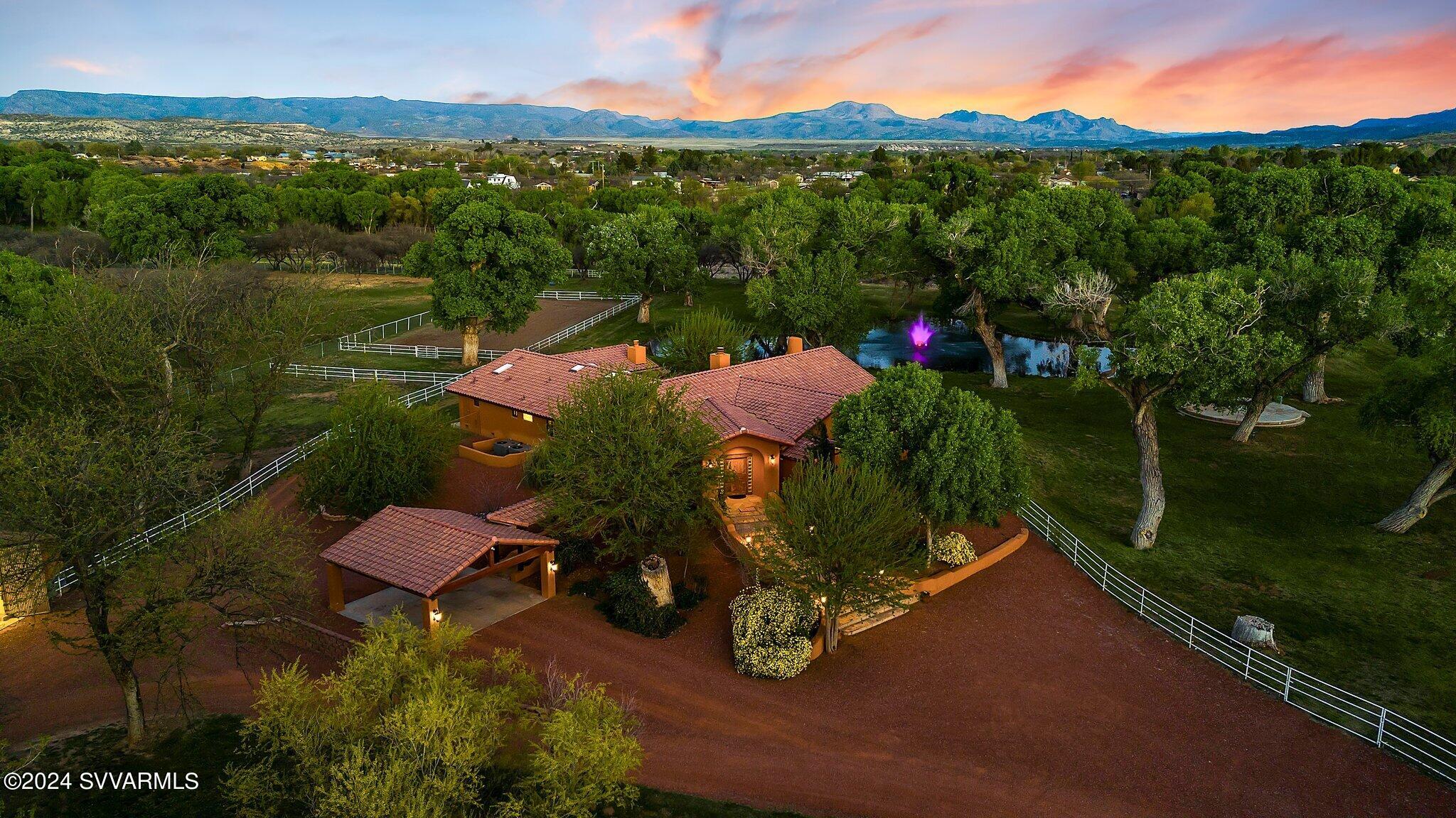 Settled within the serene embrace of the Verde Valley green belt, Rio Verde Ranchos offers a rare opportunity to experience the purity of peaceful rural luxury ranch life. This 12.1 acre privately gated riverfront estate features a 3 bed/3.5 bath main home + 1 bed/1 bath 911 sf 
guest house, 4 stall barn & tackroom, & 4 car garage. The main home has a grand living area, gourmet kitchen & dining, and a resort-like entertainment patio showcasing a built-in BBQ rotisserie, kiva fireplace, hot tub, fire bowl sculpture, and sensational views of the property's two lakes with illuminated fountains.  The climate-controlled greenhouse provides  all season gardening & an impressive wood/workshop is AA+. With 400+ ft of Verde River frontage, this luxe ranch property is a sanctuary of tranquility. Settled within the serene embrace of the Verde Valley Green Belt, Rio Verde Ranchos offers a rare opportunity to experience the purity of peaceful rural luxury living. 12+ acres and privately gated, this riverfront estate is a sanctuary of tranquility where cherished moments seamlessly unfold.

The location of the property is priceless. Quiet, serene, yet so close to vast changes in scenery and activities in this extraordinary ranch/estate, which offers a rare opportunity to experience the purity of peaceful rural luxury ranch life within 45-minute scenic drives from the red rocks of Sedona, historic Prescott, Payson, the setting for Zane Grey novels, the 1800's mining town of Jerome, the Page Springs wine region and the snowy peaks of Flagstaff that tower at 7,000 feet elevation, offers winter skiing and is home to the largest stand of Ponderosa Pines in the world. Sky Harbor Airport is only 90 minutes south.

The heart of the property is a 3 bedroom, 3.5 bath main home, featuring a grand living area with soaring ceilings and artisanal stone flooring, a gourmet kitchen and dining area, and a resort-like entertainment patio showcasing a covered patio, built-in BBQ rotisserie, kiva fireplace, 8-person hot tub, fire bowl sculpture, and sensational views of the property's two lakes with illuminated fountains. Mind-blowing sunsets and distant mountain vistas create an idyllic backdrop for year-round entertaining and outdoor enjoyment.

A newly remodeled one-bedroom, one-bath stand-alone guest house offers captivating views of rolling green hills and mature trees where native blue herons nest in the tall lakeside Cottonwood trees. This pastoral irrigated property includes a climate-controlled brick greenhouse to grow herbs and vegetables throughout all seasons! A livestock barn & horse corrals are ready to welcome horses or other livestock. A performance stage will be the hallmark of your ranch entertainment event music and great speech memories. A four-car garage has an impressive 500 sq ft workroom and separate woodwork area with a canning kitchen with a hydration station and full bath with a cowboy copper soaking tub. 

Rio Verde Ranch features 400+ feet of Verde River frontage, including two access points for fishing or kayaking. It is located just 35 miles from Sedona, in the heart of Camp Verde, with easy access to Flagstaff for skiing and Scottsdale for shopping. The town is quaint, with a grocery store, medical center, amazing restaurants, and boutique mom-and-pop businesses sprinkled throughout. This luxe ranch property seamlessly blends unparalleled luxury with astonishing natural beauty, promising an extraordinary living experience for those who appreciate a sophisticated style of farming and ranching.

2021-2023
New roofing on house, guest house and garage
Added full bath to garage
New icemaker and R/O
Remodeled interior of Guest House...all new flooring and bath fixtures
Excavated ponds to original size
New Fountains/pumps/aerators/lights thru Solitude Lake Management
All new bladder tanks (4) in main well room $10.5K
All new HVAC units and duct work in house/guest house and garage
Fencing
Added 1 rail height to large portion of fencing
All new no climb including pastures
Painted all fencing
New or repaired to new gates throughout property
Planted Fruit trees in front pasture and guest house yard
New exterior lighting fixtures
Remodeled skylighted 2 car garage
Cherry butcher block counters
Copper sinks
New flooring
built in shelving
plumbing for washer/dryer
All water heaters on property upgraded and replaced
All tankless except for 80 gallon in garage
New brick patio outside back door and under hot tub
New Hot tub.....maintained weekly by Pool Medic
All interior fans replaced
SOLAR in guest house/garage with 3 TESLA Powerwalls
All new Andersen windows and doors in house, guest house and skylighted garage room
All new irrigation lines, heads and automatic controls 
Garden is piped to irrigate 16 rows with drip tape
All garage door openers and rails replaced
New arm, motor and controls for front gate
Property Wide internet brought from street (350 feet) with boosters throughout property
Security system can be operated by phone and panels to open the gate/doors/turn on lights, view camera scenes, etc
New 60 GPM well near back of property can be switched to service entire property by opening a valve (backup for main well)
Greenhouse built...
lighted
auto watering drip lines
Replace gas grill on house back patio
Also added Argentine grill that cooks with wood
Replaced BBQ area and added counter top
Repainted inside of House/Guest House/Garageall rooms
Remodeled Kitchen
All new appliances 
Added Sedona Red cinder rock throughout property (all but driveway was dirt that made a muddy mess) including areas in front and back of house slopes
$130,000 in tree trimming and removals from original condition