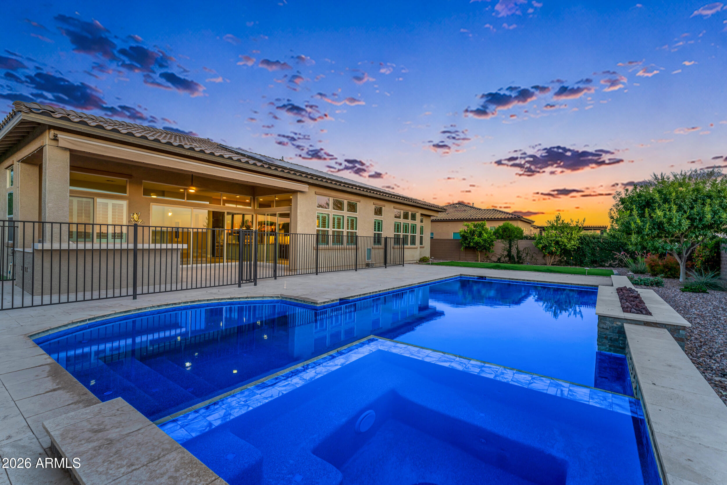 Completely paid off solar AND space to park your RV! These are just two of the many great features of 76th Ln. This stunning single-story residence is located in NW Peoria's highly desirable, gated, boutique community of Deseo. This impeccably designed home features a chef's kitchen with gourmet stainless steel appliances, including a 36'' gas cooktop with hood, double ovens, granite countertops, designer backsplash, oversized island, stacked beautiful cabinetry, a large walk-in pantry, and FOUR en-suite bedrooms. Fiber optic internet is available at this home! The expansive great room is filled with natural light and highlighted by a 90-degree corner sliding glass door, creating seamless indoor/outdoor living. Thoughtful upgrades include a custom built-in desk in the home office, library shelving with ladder in the media room, plantation shutters, 12' ceilings, square drywall corners, 5" contemporary baseboards, two-tone interior paint, and 18" x 36" tile throughout (bedrooms excluded). The spacious laundry room flows to the primary bathroom, while the luxurious primary bath provides a spa-like retreat. Guests are first wowed by your private courtyard, and covered patio, complemented by an iron entry door. The resort-style backyard is ideal for entertaining, featuring an extended covered patio with retractable awning, gazebo sitting area with fireplace, built-in grill, soothing spa, and refreshing pool with fire feature. Additional highlights include a concrete pad leading to an RV gate with RV parking in the backyard. This exceptional home offers a perfect balance of luxury, functionality, and indoor-outdoor living.