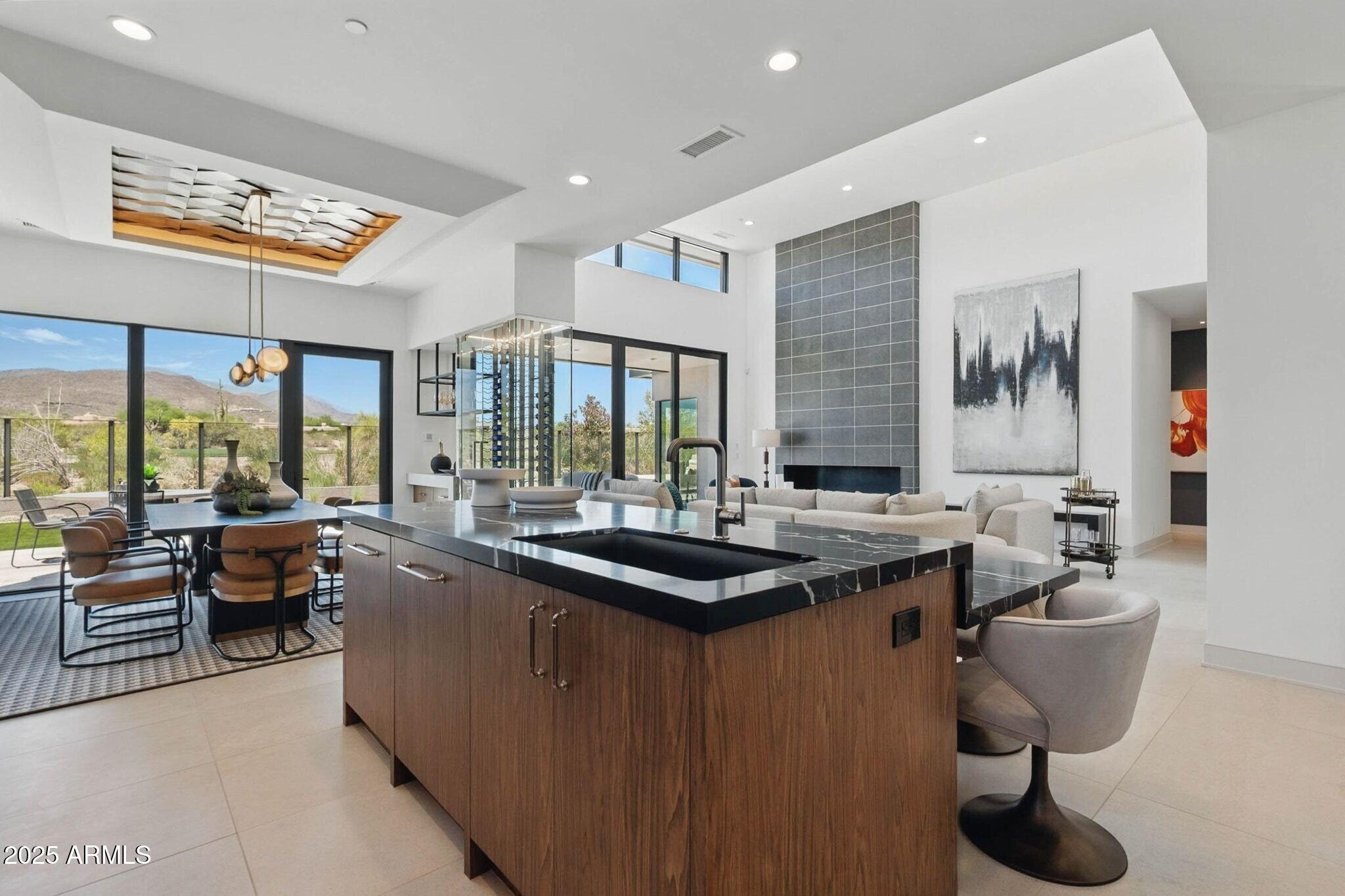 A full golf membership is available immediately!!! 
This stunning Haven Lock-and-Leave Custom Home by Cullum Homes comes furnished and move-in ready! A separate entrance leads to the ensuite casita, perfect for hosting visitors. The large glass front door opens into the great room, featuring a floor-to-ceiling fireplace, chef's kitchen, and dining area.
The kitchen is a showstopper, with exquisite attention to detail, including mixed materials, custom quartz and onyx finishes, two-tone cabinetry, and top-tier appliances like Sub-Zero, Wolf, and Cove. The walk-in butler's pantry, custom wine cellar, and dry bar make this space perfect for entertaining. The great room and primary suite both offer breathtaking views of the 13th hole of the Renegade Golf Course and distant mountains, creating a peaceful and scenic backdrop. The spa-like primary bath includes double sinks, a soaking tub, a large shower, and a custom walk-in closet by Closet Masters.
The home also features an office, laundry room, built-in desk, and plenty of extra storage. With a 3-car garage, there's ample room for all your toys and a golf cart.
Step outside to the tranquil backyard, where a water feature cascades into the pool. Enjoy the outdoor BBQ, fire pit, and multiple sitting areas, all with stunning views of the golf course and mountains.
Seven Desert Mountain offers an unparalleled lifestyle-start golfing today!